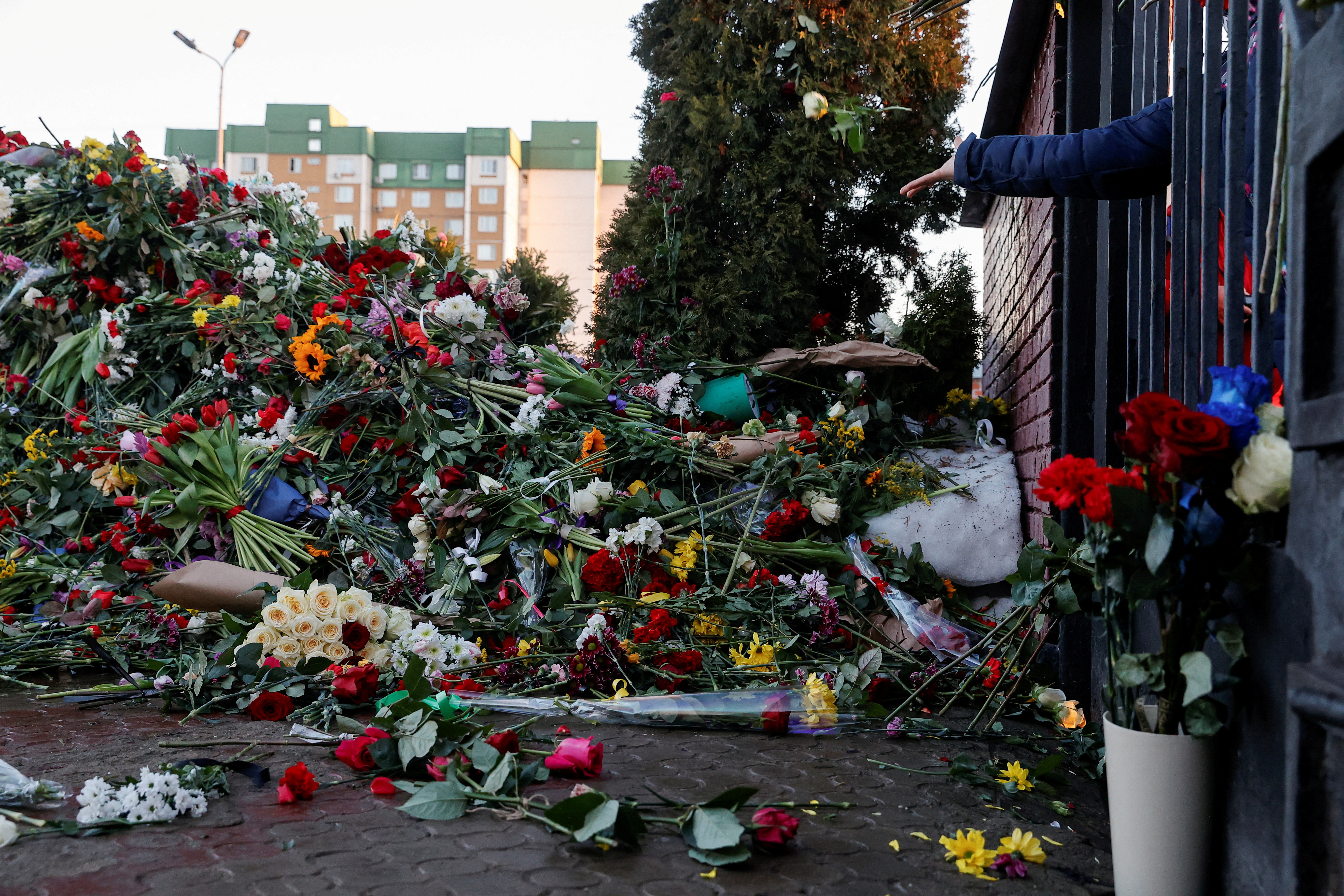 A person throws flowers towards the grave of Russian opposition politician Alexei Navalny while standing in front of a closed entrance to the Borisovskoye cemetery, in Moscow, Russia, March 3, 2024. REUTERS/Stringer TPX IMAGES OF THE DAY