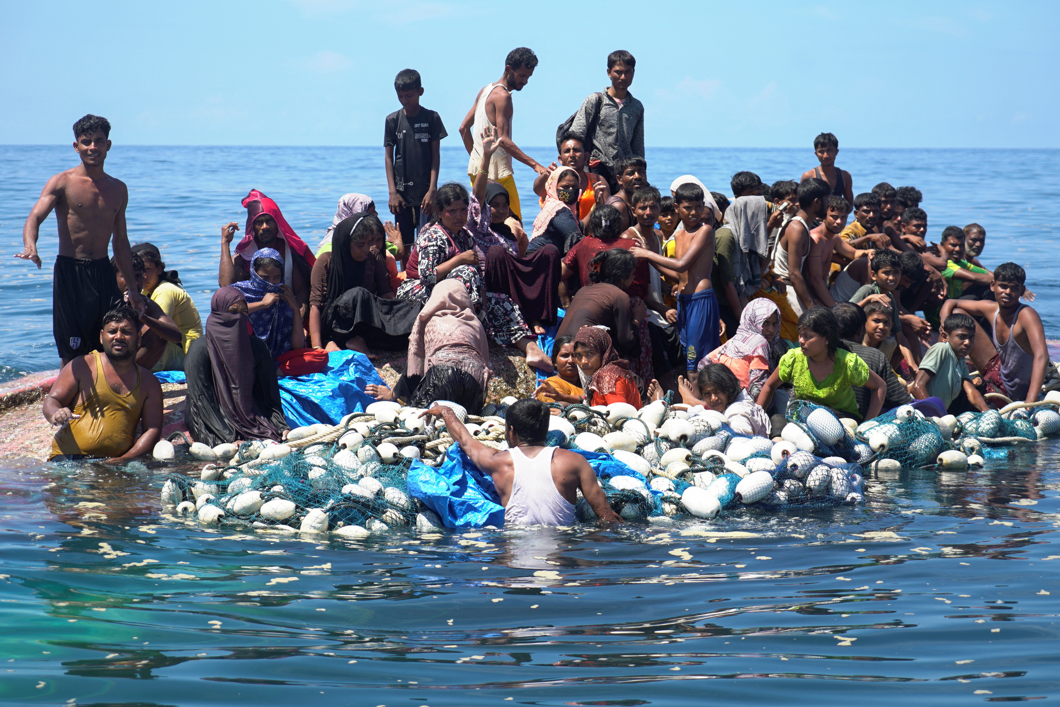 Rohingya crowded onto the hull of their upturned boat