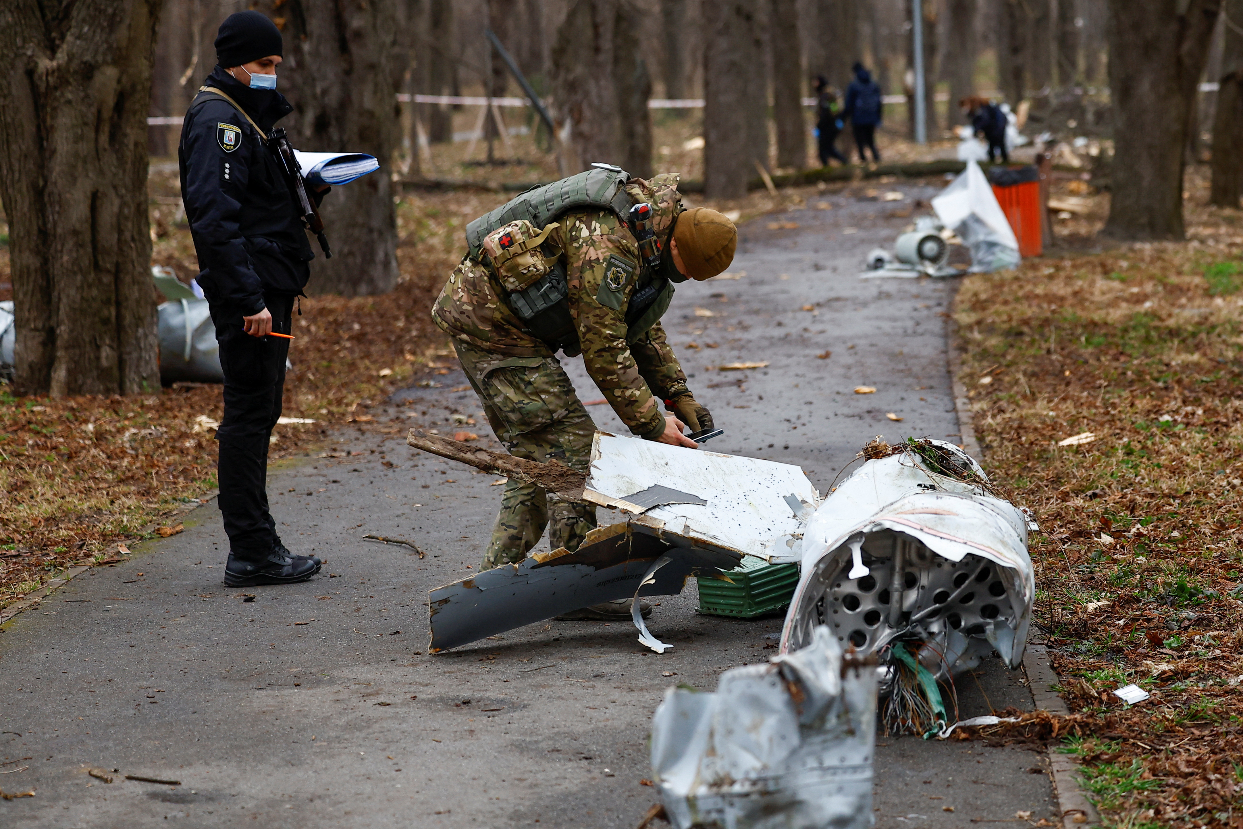 Police officers inspect a part of a Russian Kh-55 cruise missile