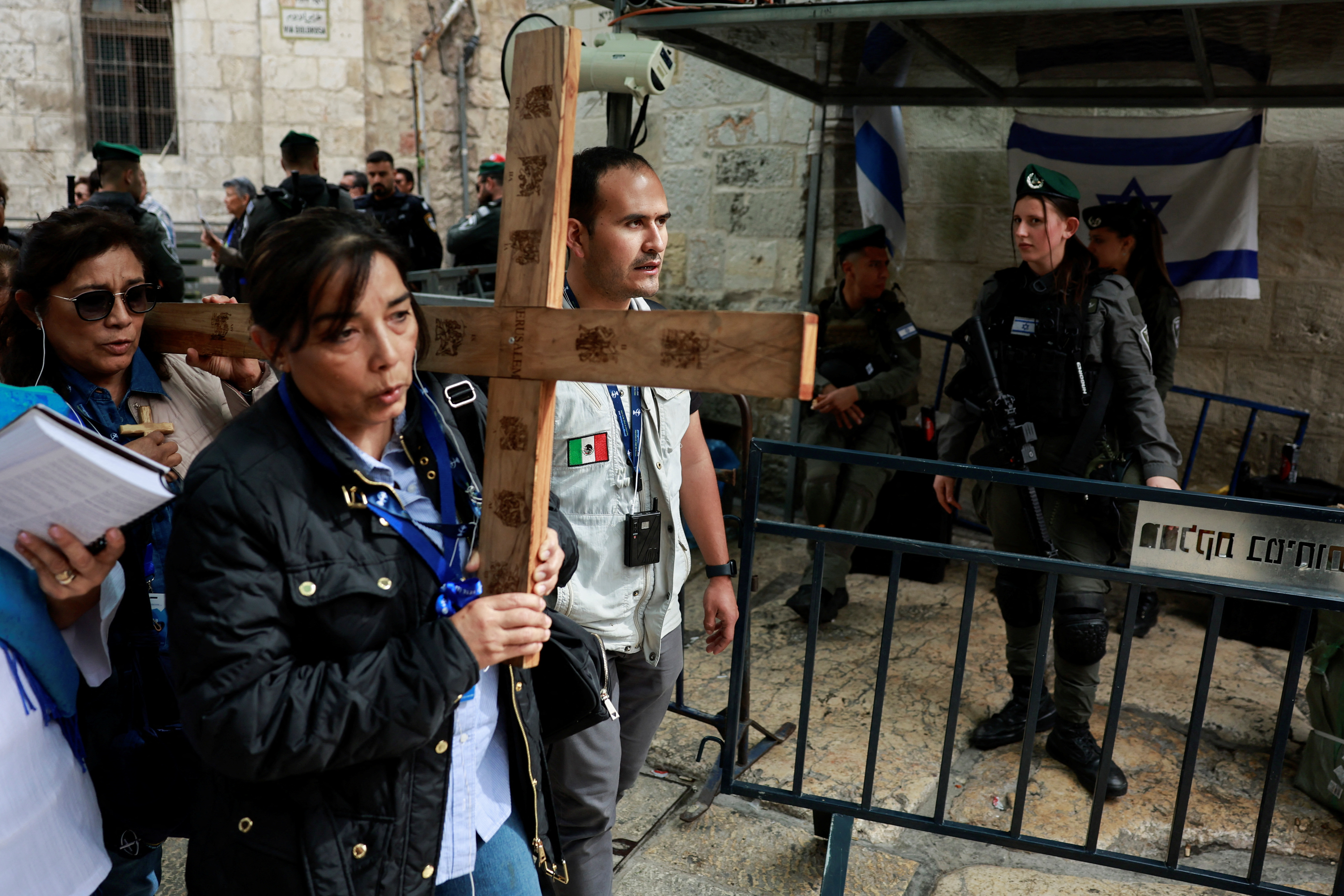 Worshippers carry a cross as they participate in the Good Friday procession of the Via Dolorosa in Jerusalem’s Old City on March 29, 2024