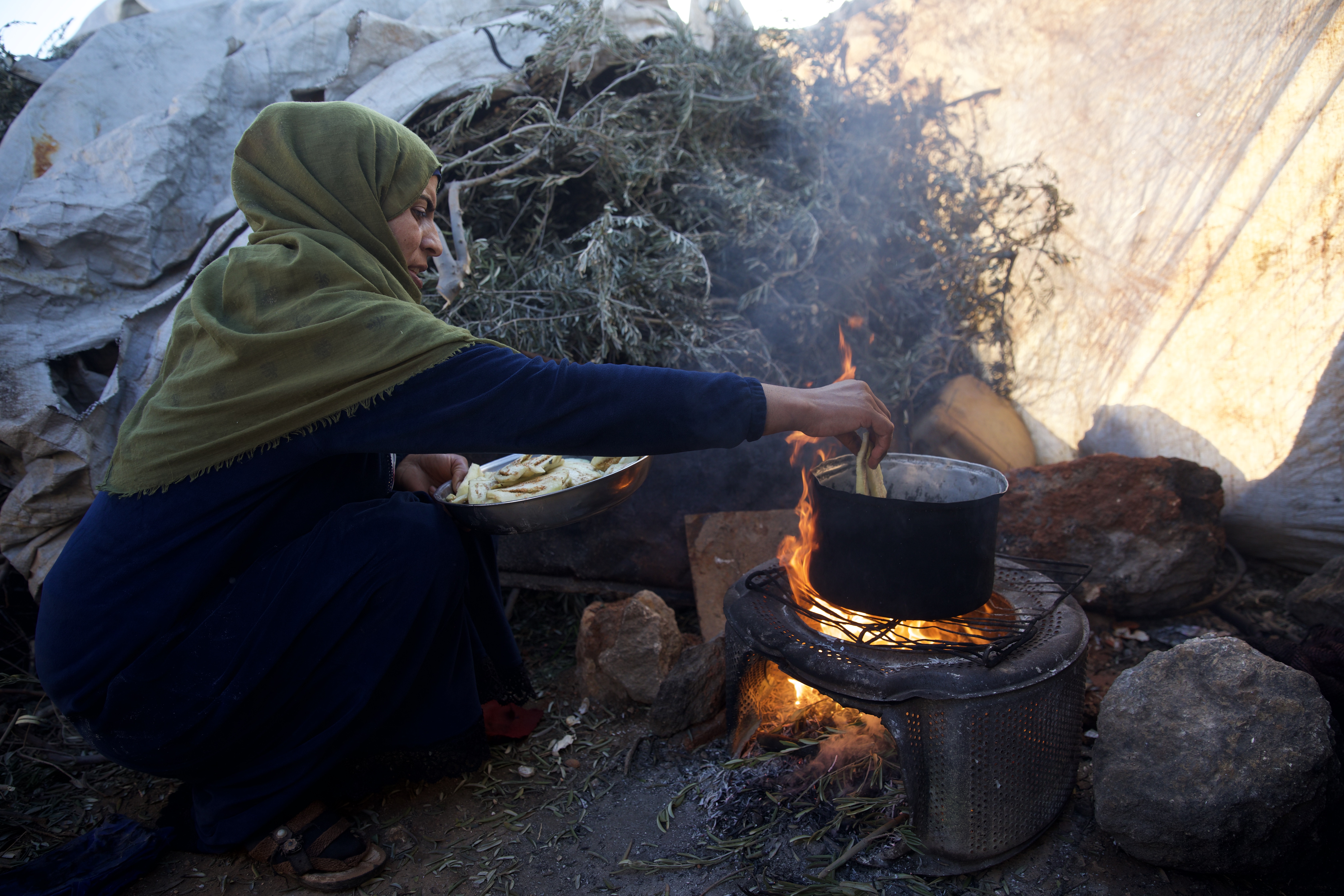 Bayan managed to get the fire going in their outdoor cooking space and set to frying vegetables in her battered, blackened pot