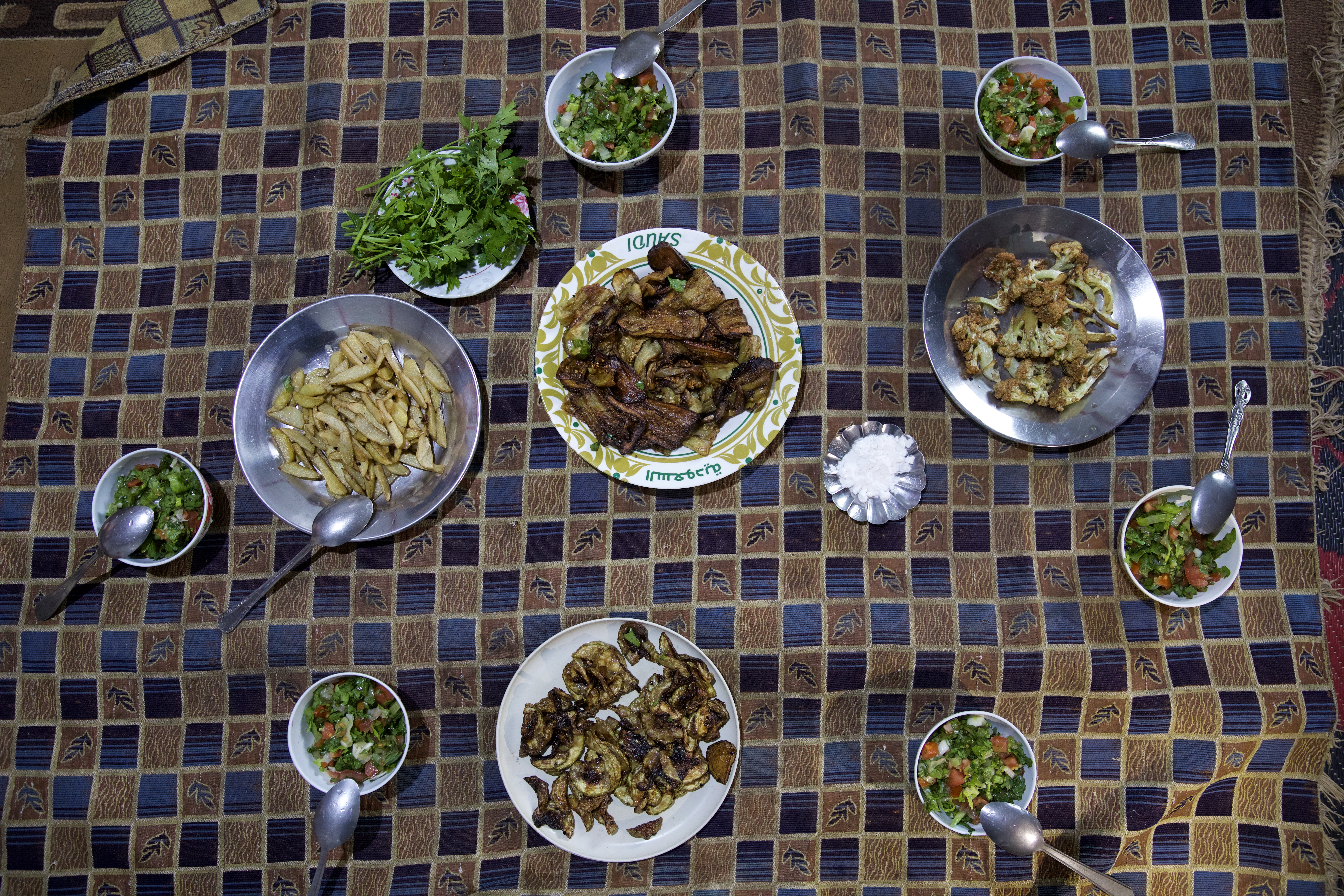 Bayan remembers past Ramadans when the family table was laden with rich, complicated dishes. But they are happy to be together, sharing this simple meal of fried vegetables and salad