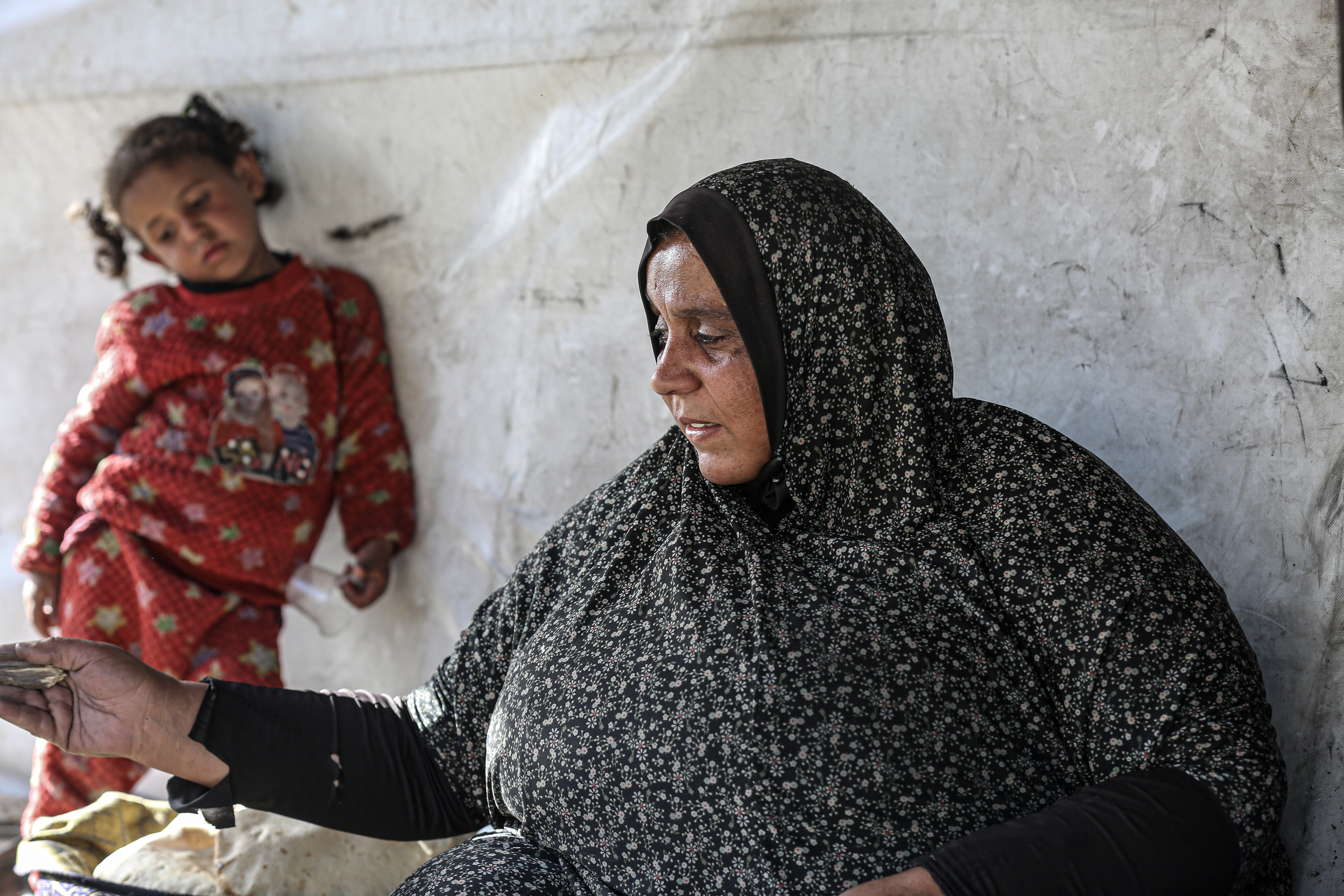 Nada Abdelsalam, 34, bakes bread over a wood fire outside her tent in central Gaza