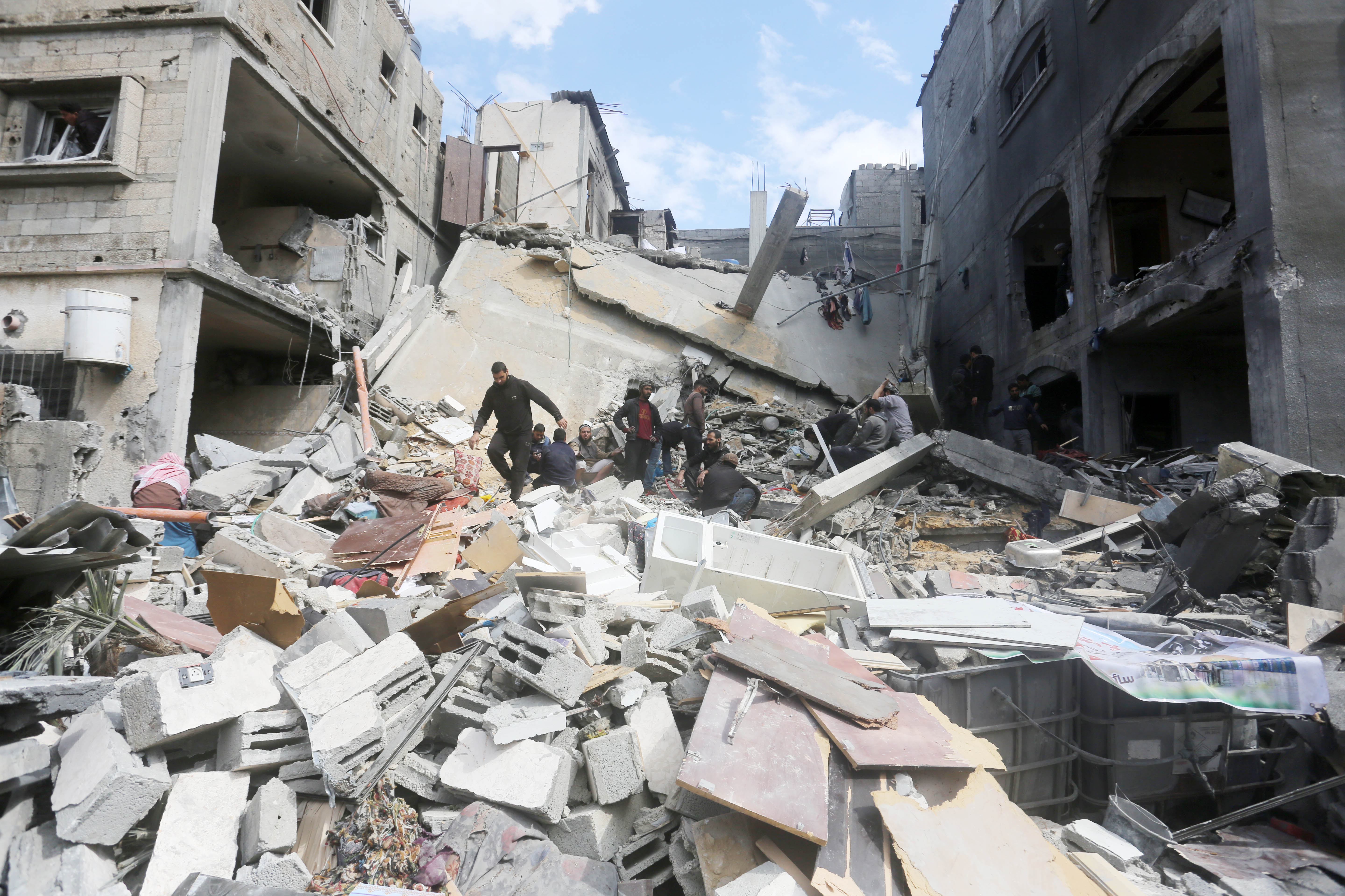 Palestinians gather to inspect a destroyed building following an Israeli attack on Deir el-Balah on March 8