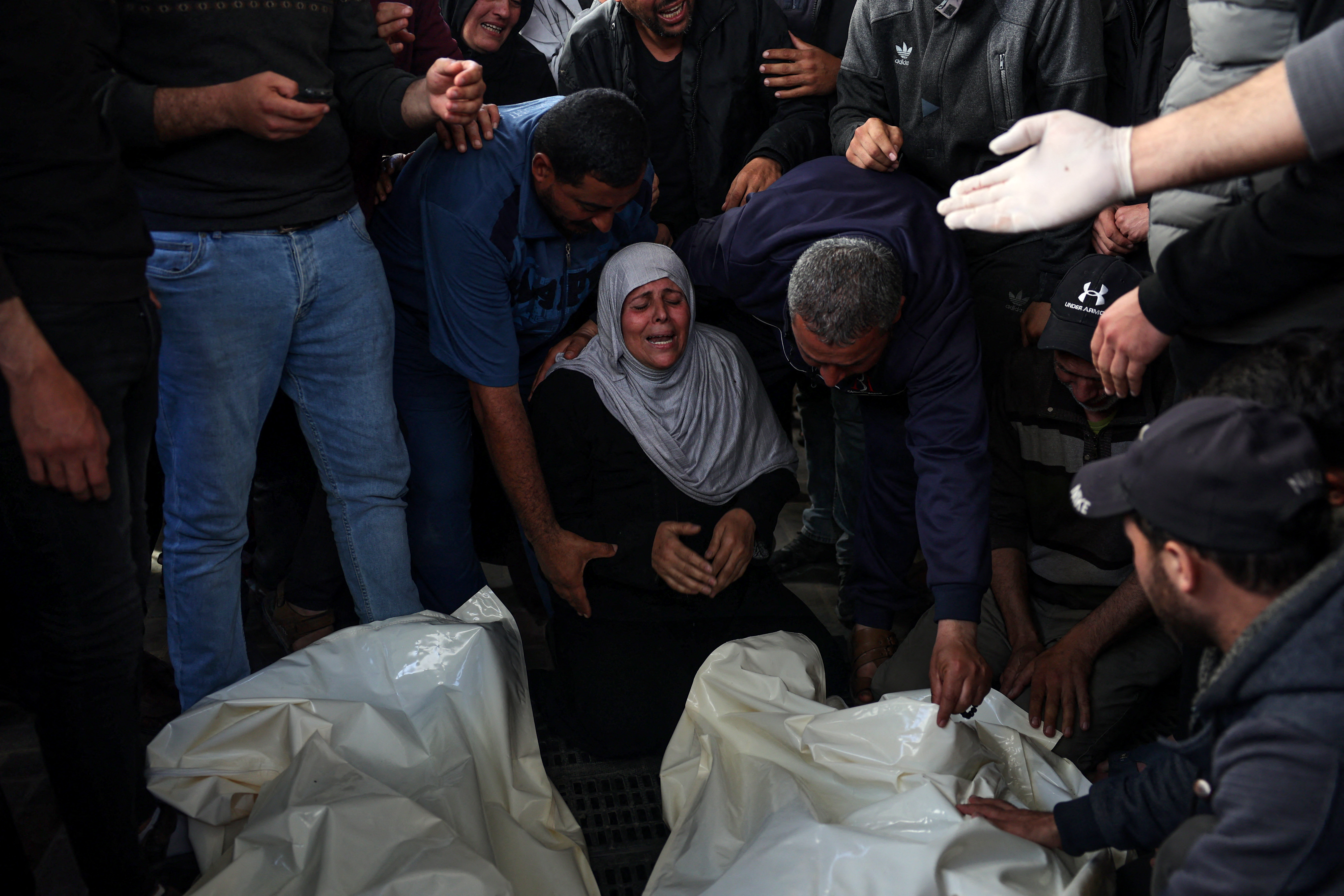 Palestinian mourners cry over the bodies of loved ones at Al-Najjar Hospital in Rafah