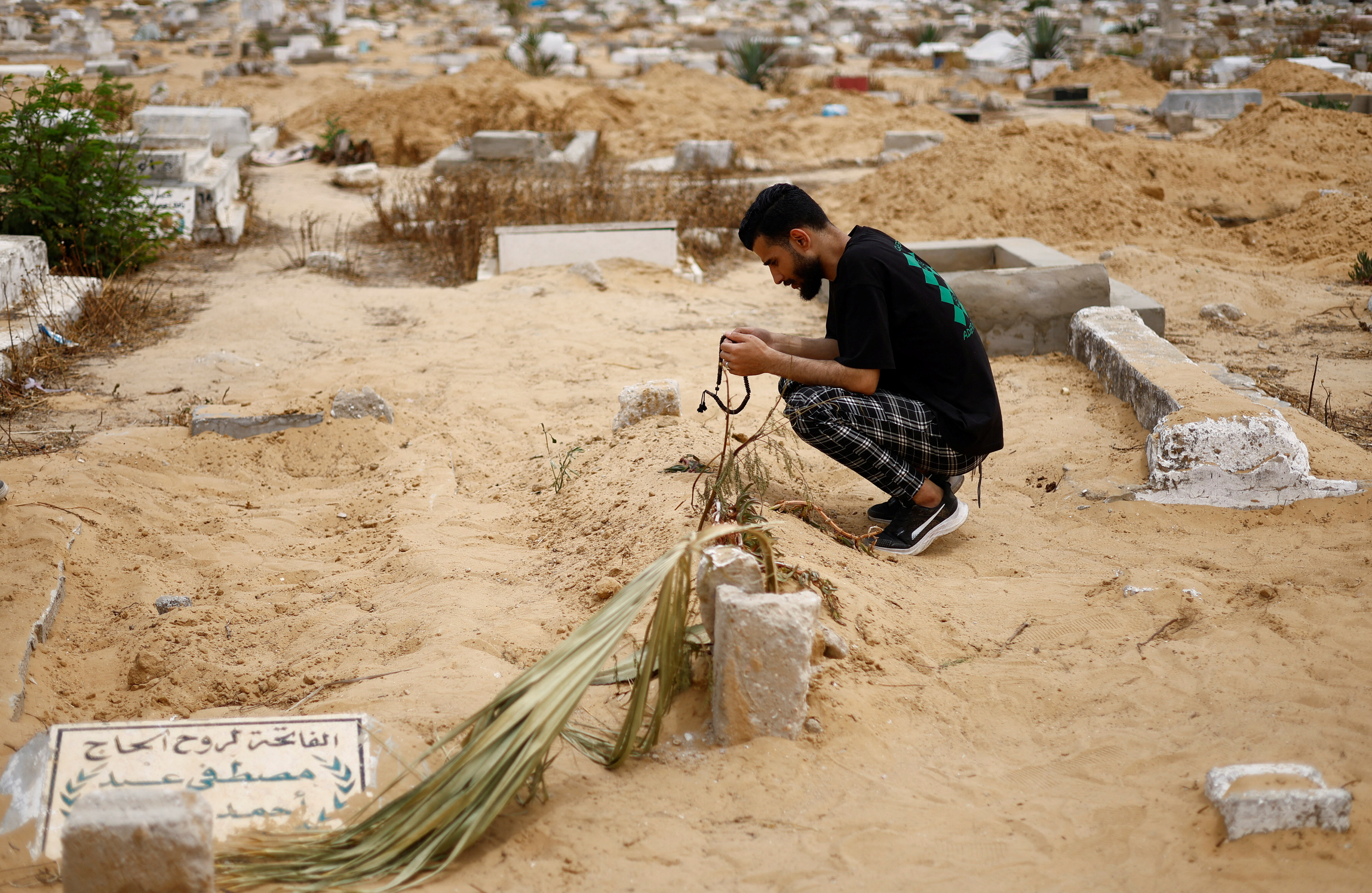 The baby girl’s uncle crouches next to her grave in Rafah in the southern Gaza Strip, April 26