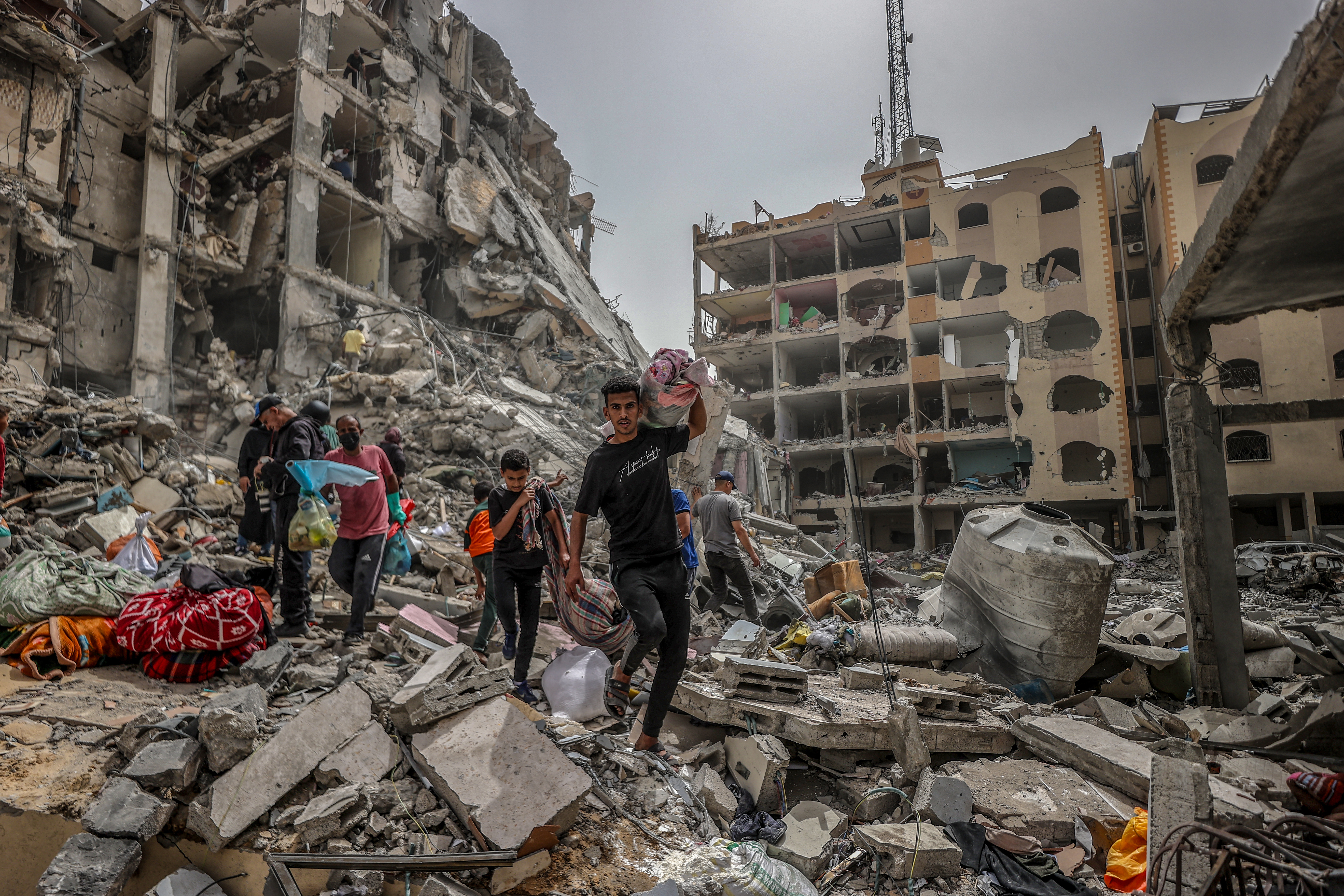 Palestinians living in Nuseirat refugee camp collect usable items among the rubble of destroyed buildings after Israel’s withdrawal from the camp in Deir el-Balah, Gaza, on April 18, 2024