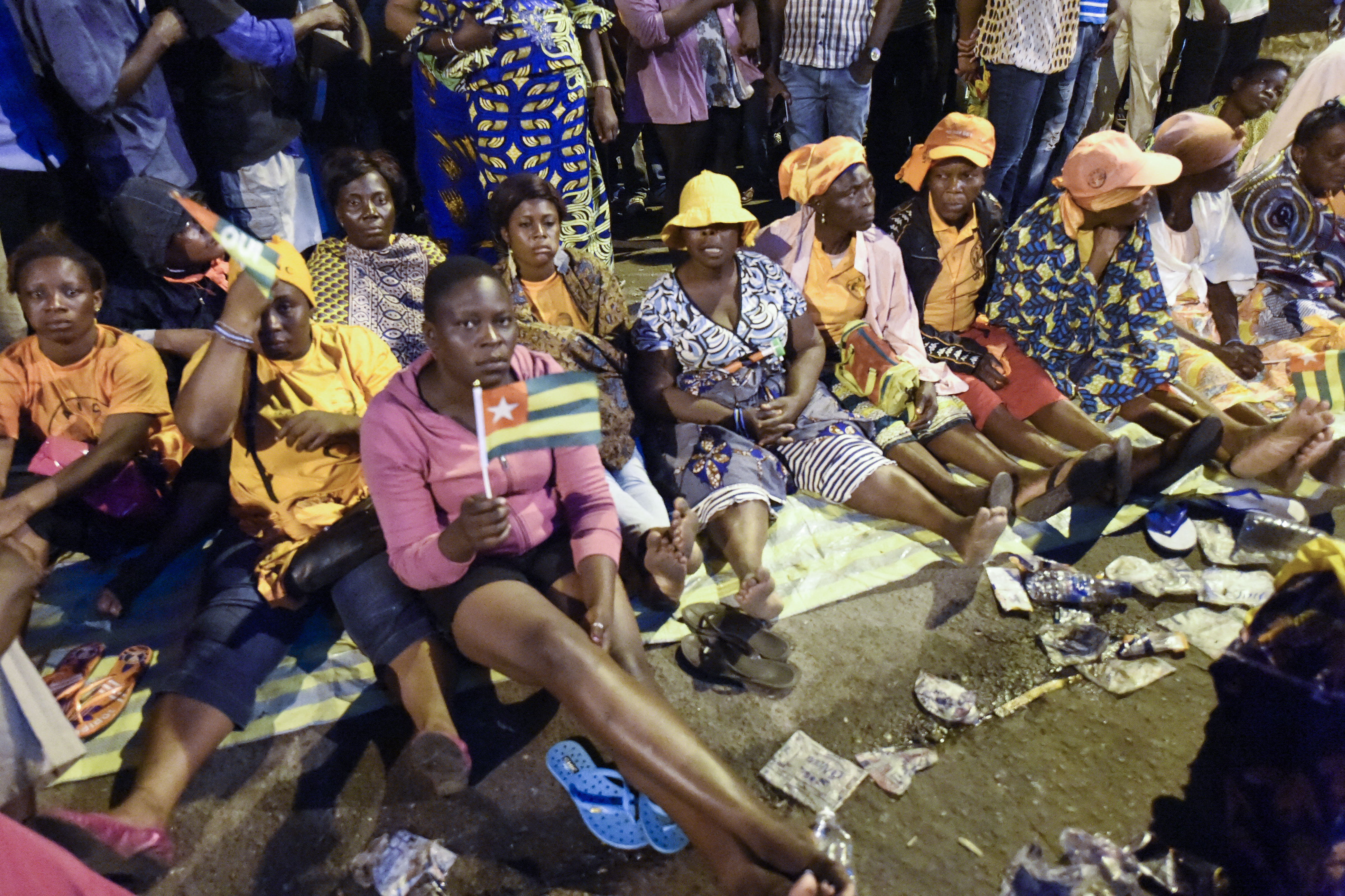 Togolese opposition supporters sit on a street as they keep an all-night vigil to press for constitutional reform in 2017