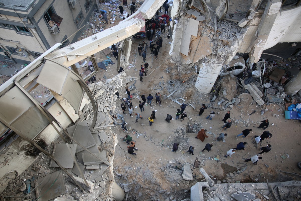 Palestinians gather around the burned and destroyed Al-Shifa Hospital