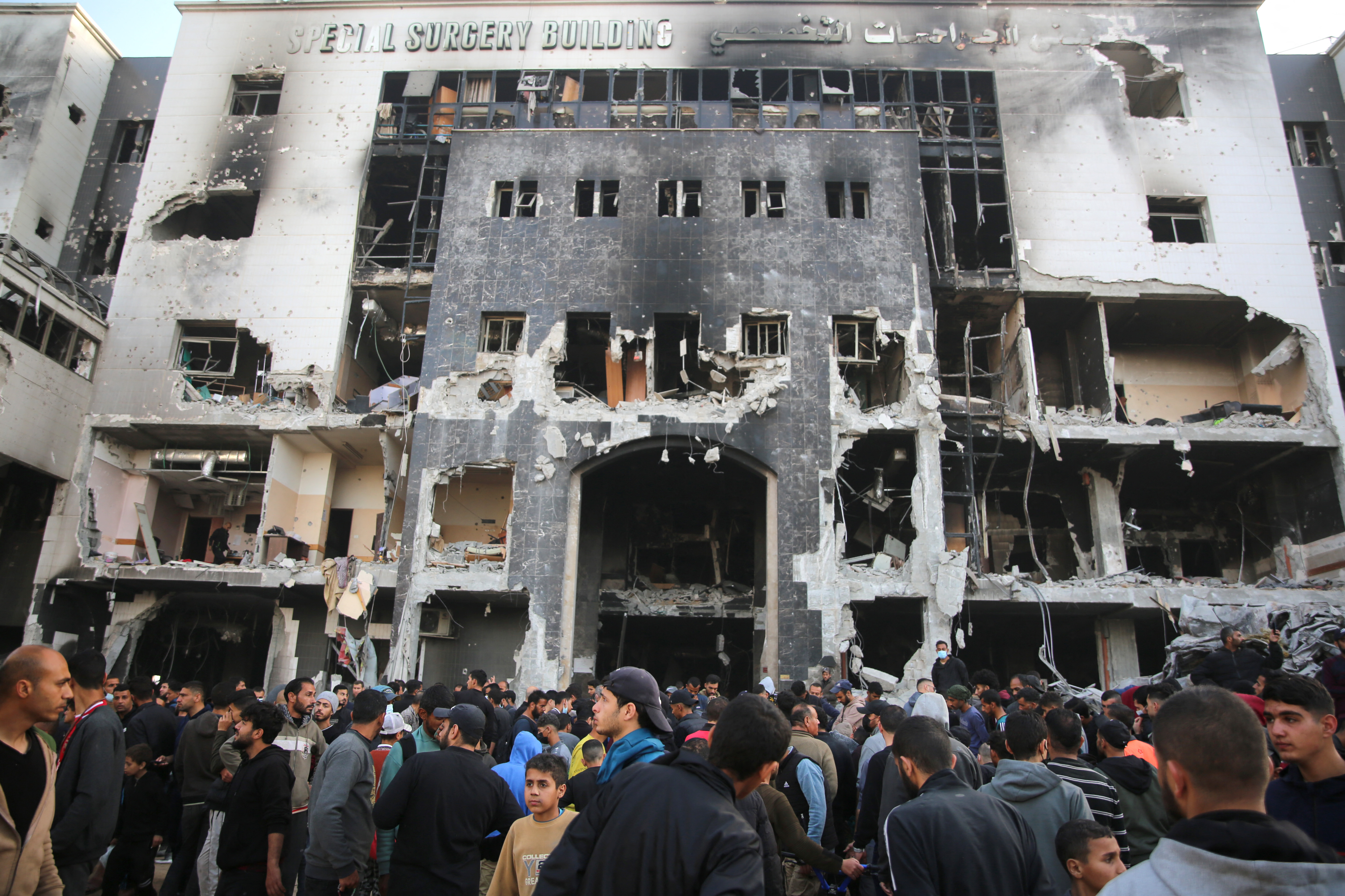 people stand in front of a blackened building with the words surgery department
