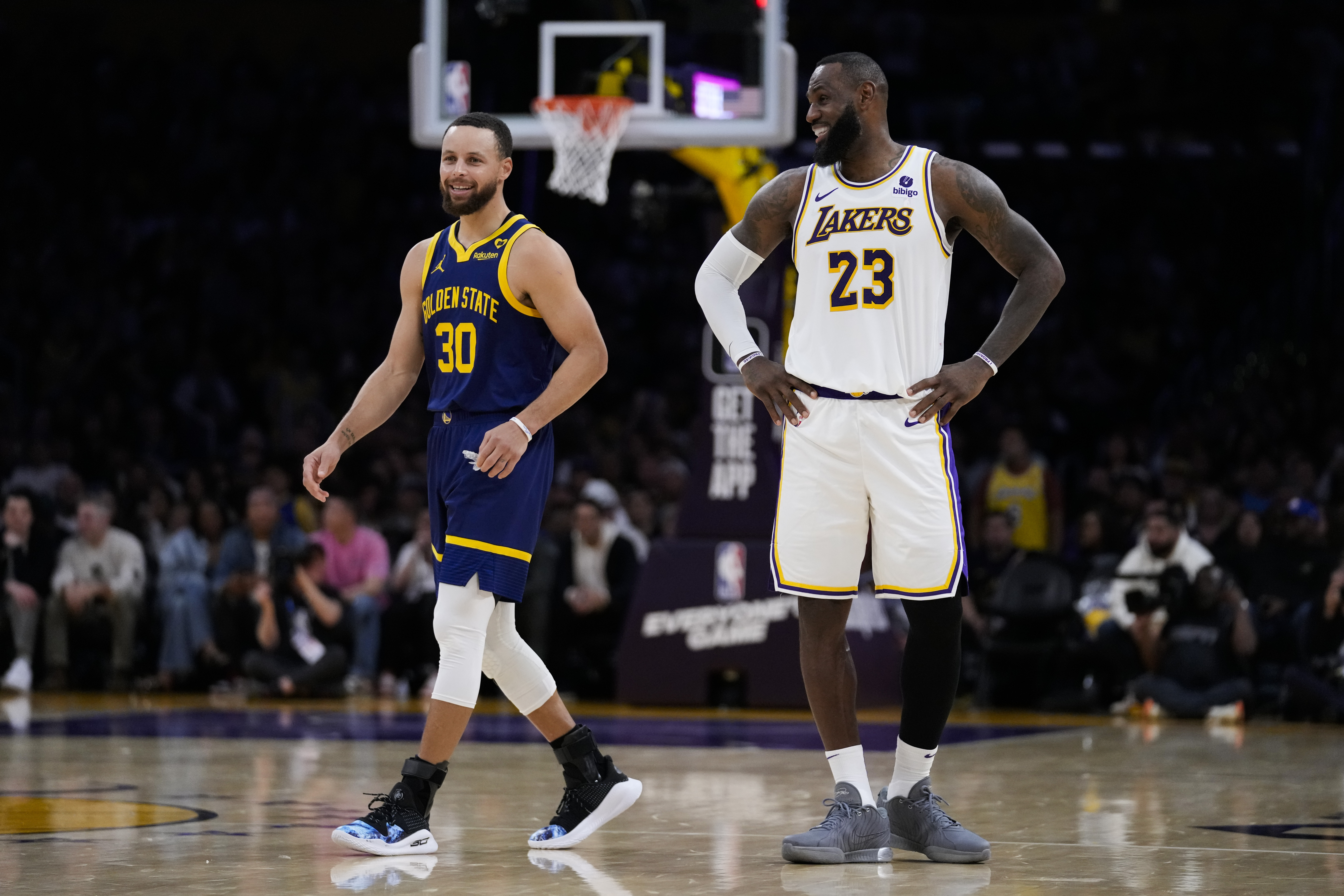 Stephen Curry (30) and LeBron James (23) talk on court.