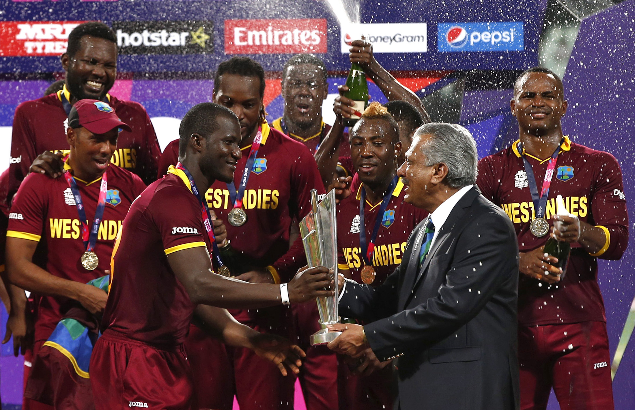 West Indies captain Darren Sammy receives the trophy from Zaheer Abbas, president of the International Cricket Council, after they won the 2016 final