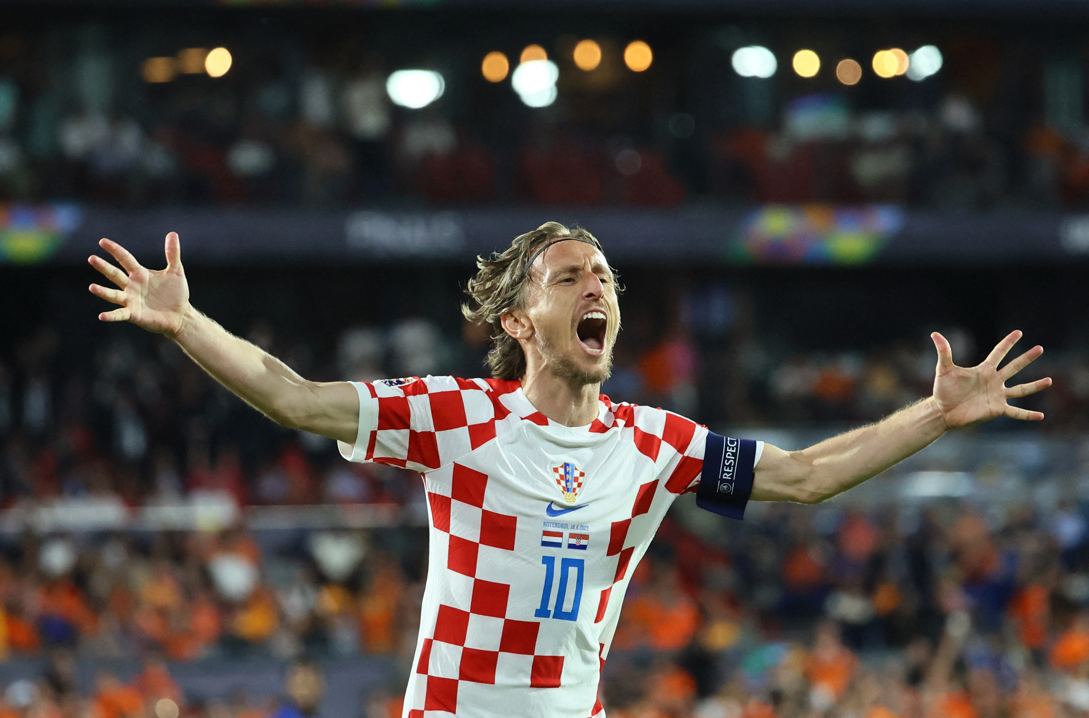Football player gestures to crowd after goal score.