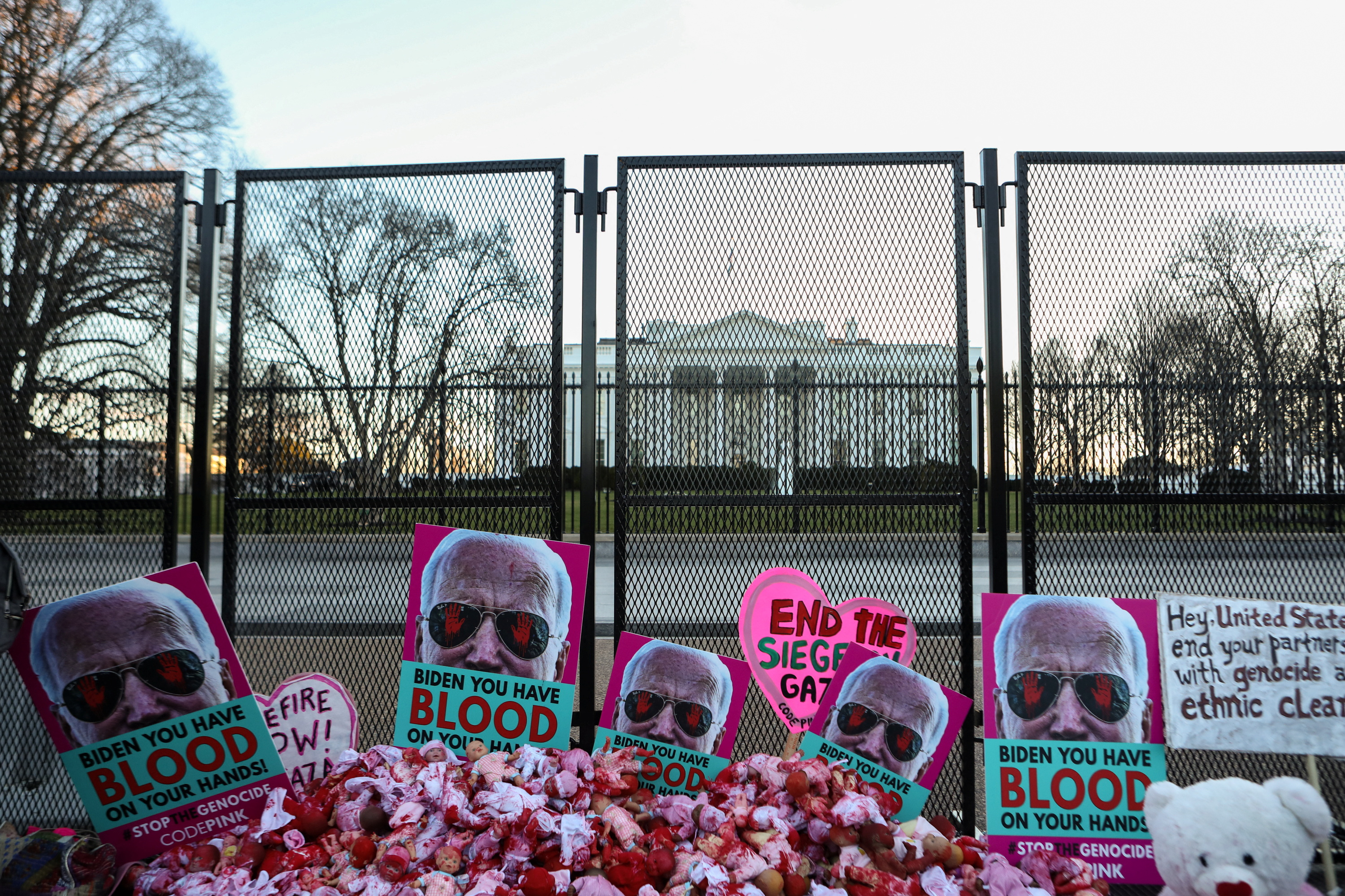 Posters of U.S. President Biden and plastic dolls are kept next to a fence as people take part in the "March on Washington for Gaza,"