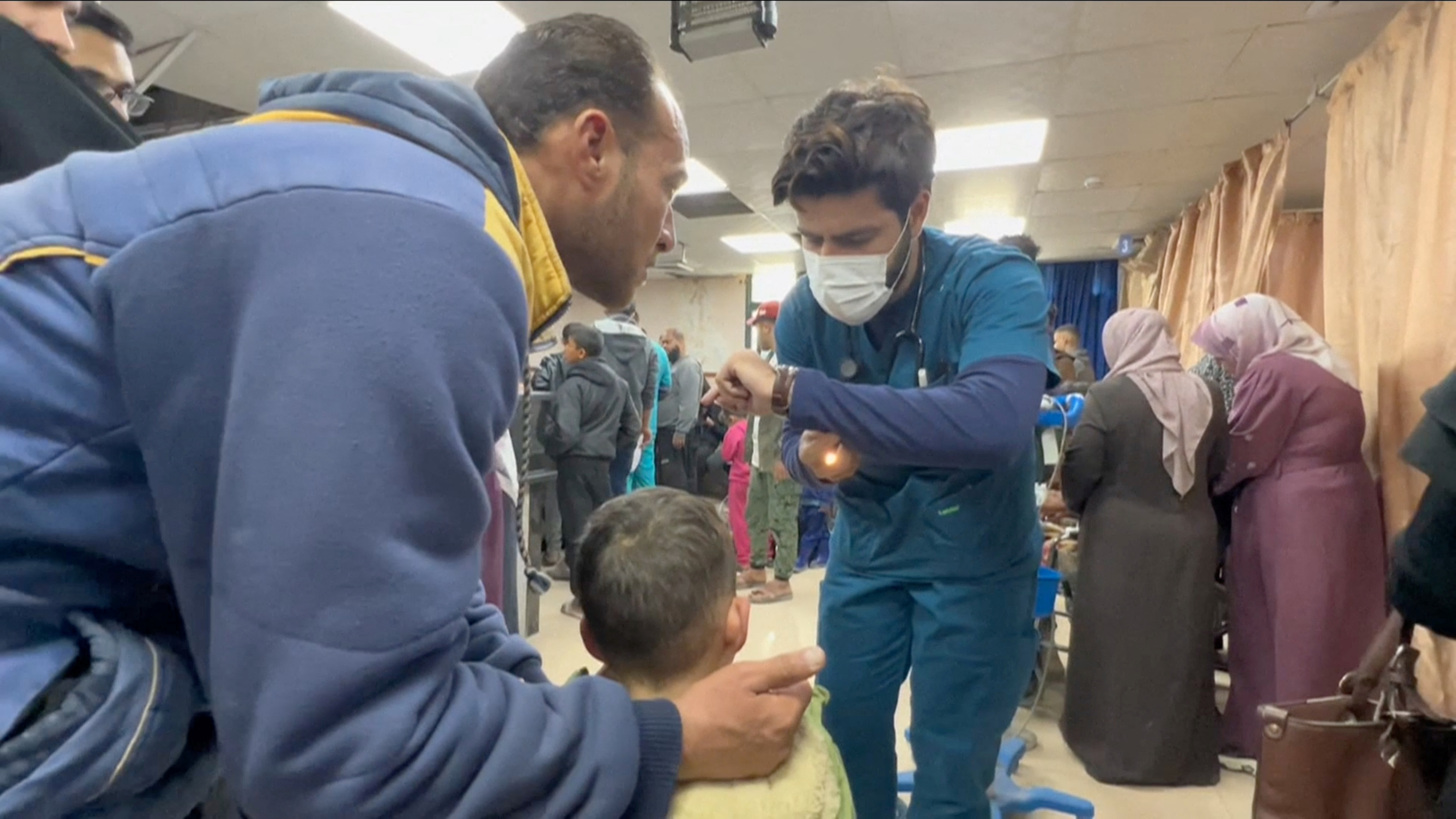 A volunteer doctor examines patients at Al-Aqsa Hospital, amid the ongoing conflict between Israel and Palestinian Islamist group Hamas, in Deir Al-Balah, Gaza, in this screen grab obtained from a handout video released March 18, 2024. World Health Organization (WHO)/Handout via REUTERS THIS IMAGE HAS BEEN SUPPLIED BY A THIRD PARTY. MANDATORY CREDIT.