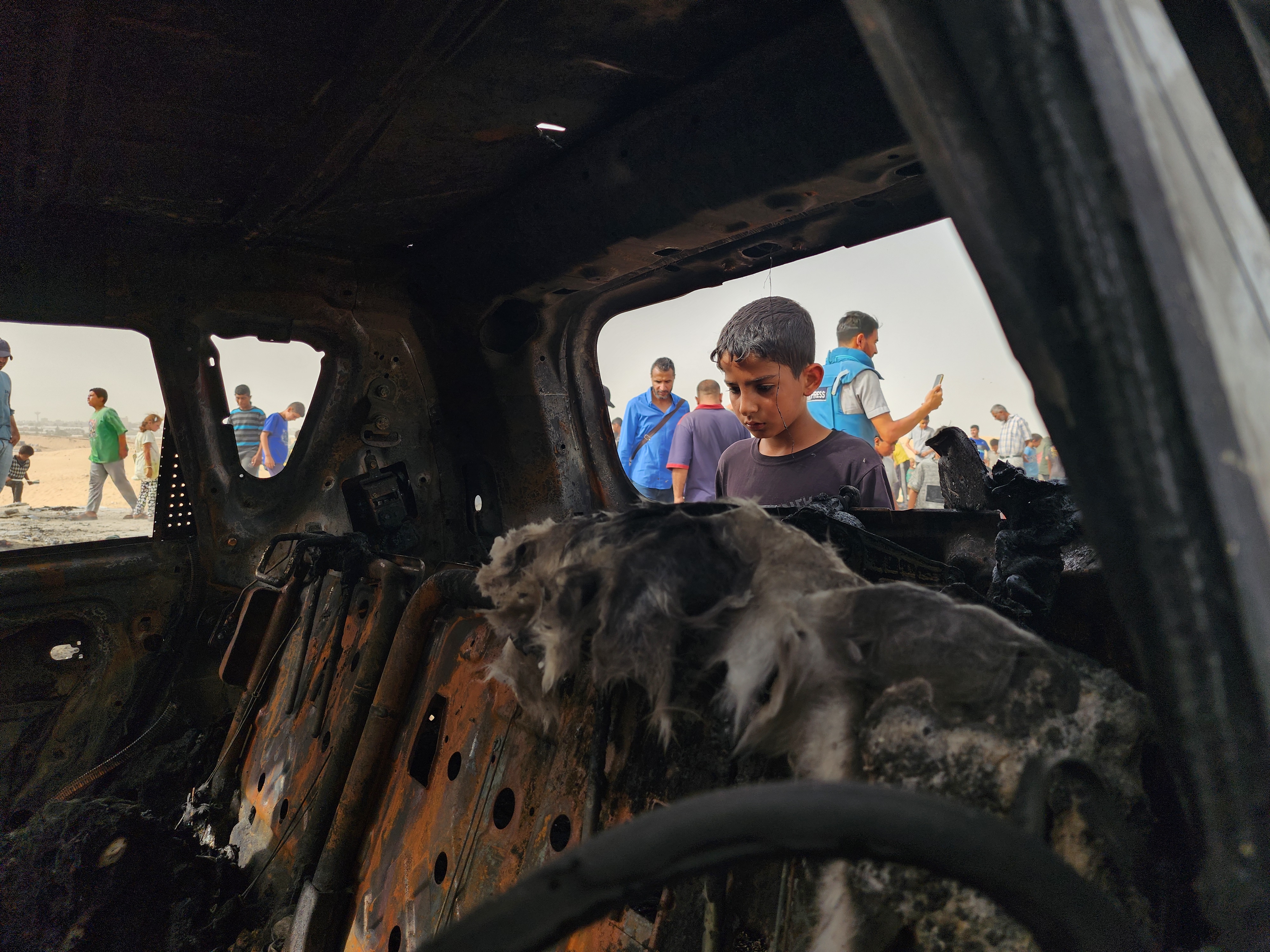 A displaced Palestinian child looks at some of the destruction after Israeli aircraft bombed shelters of displaced Palestinians in Rafah on May 27, 2024