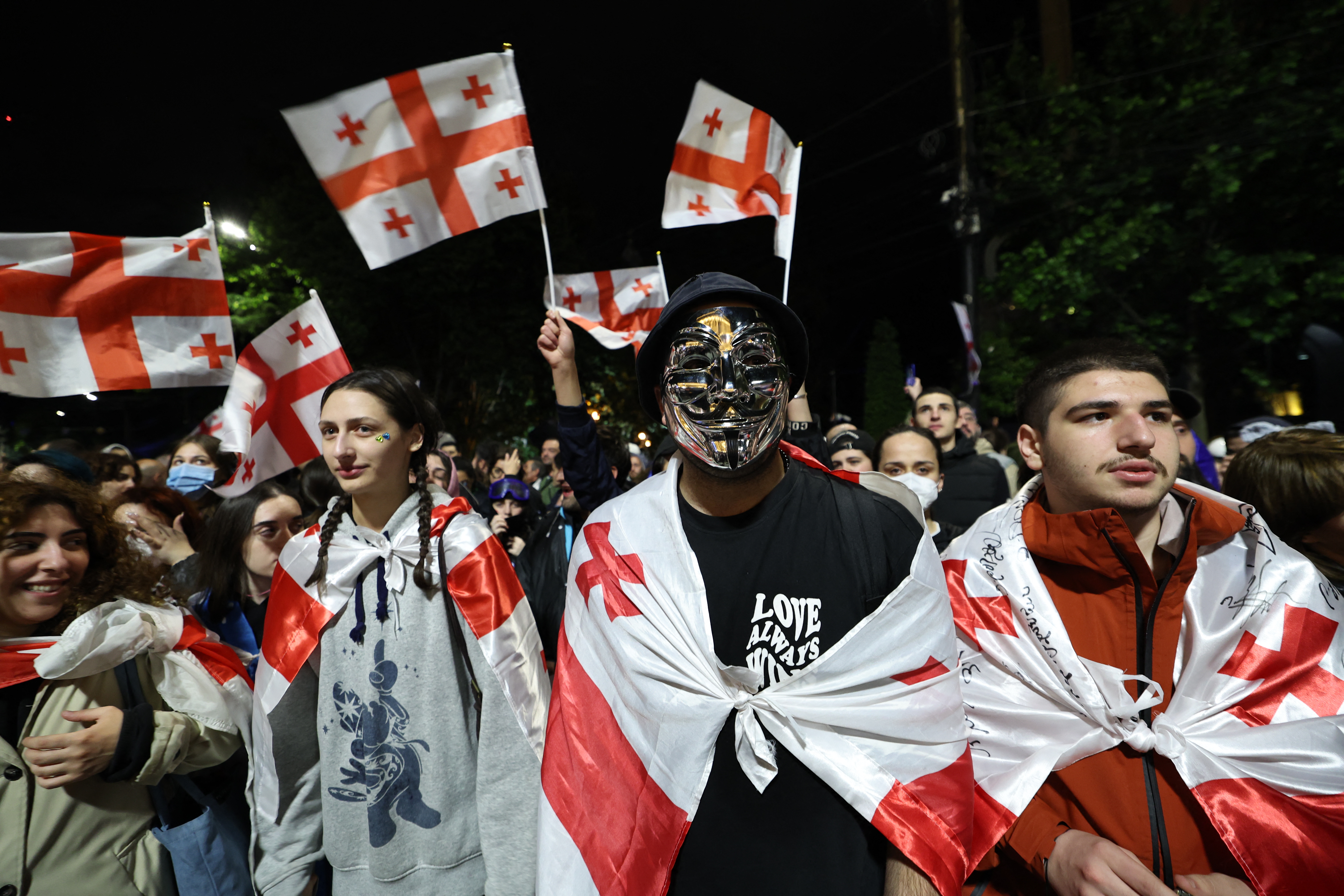 People waving Georgian flags as they protest against the 'foreign agents' bill