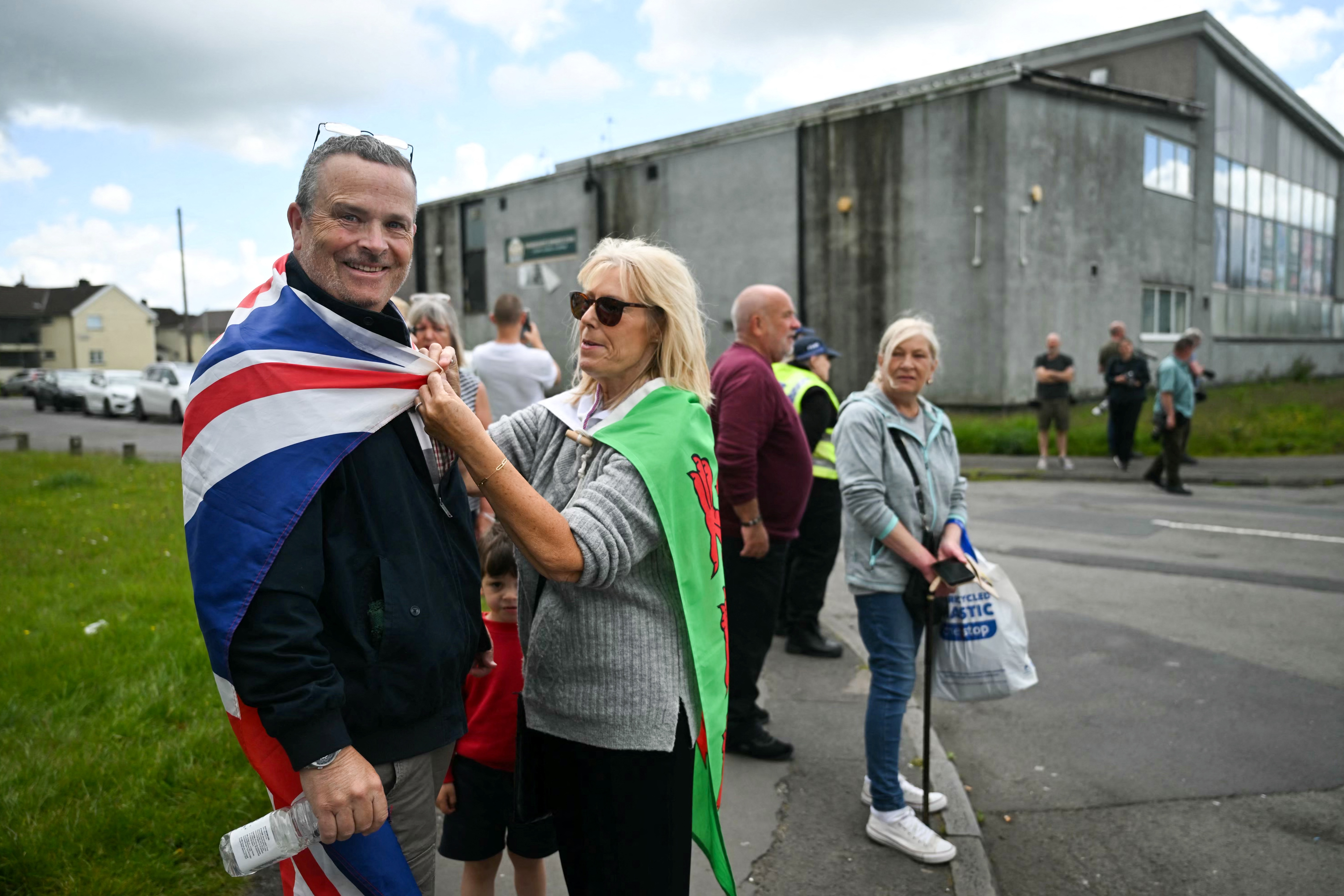 Locals wait for the arrival of leader of Reform UK Nigel Farage in Merthyr Tydfil, south Wales