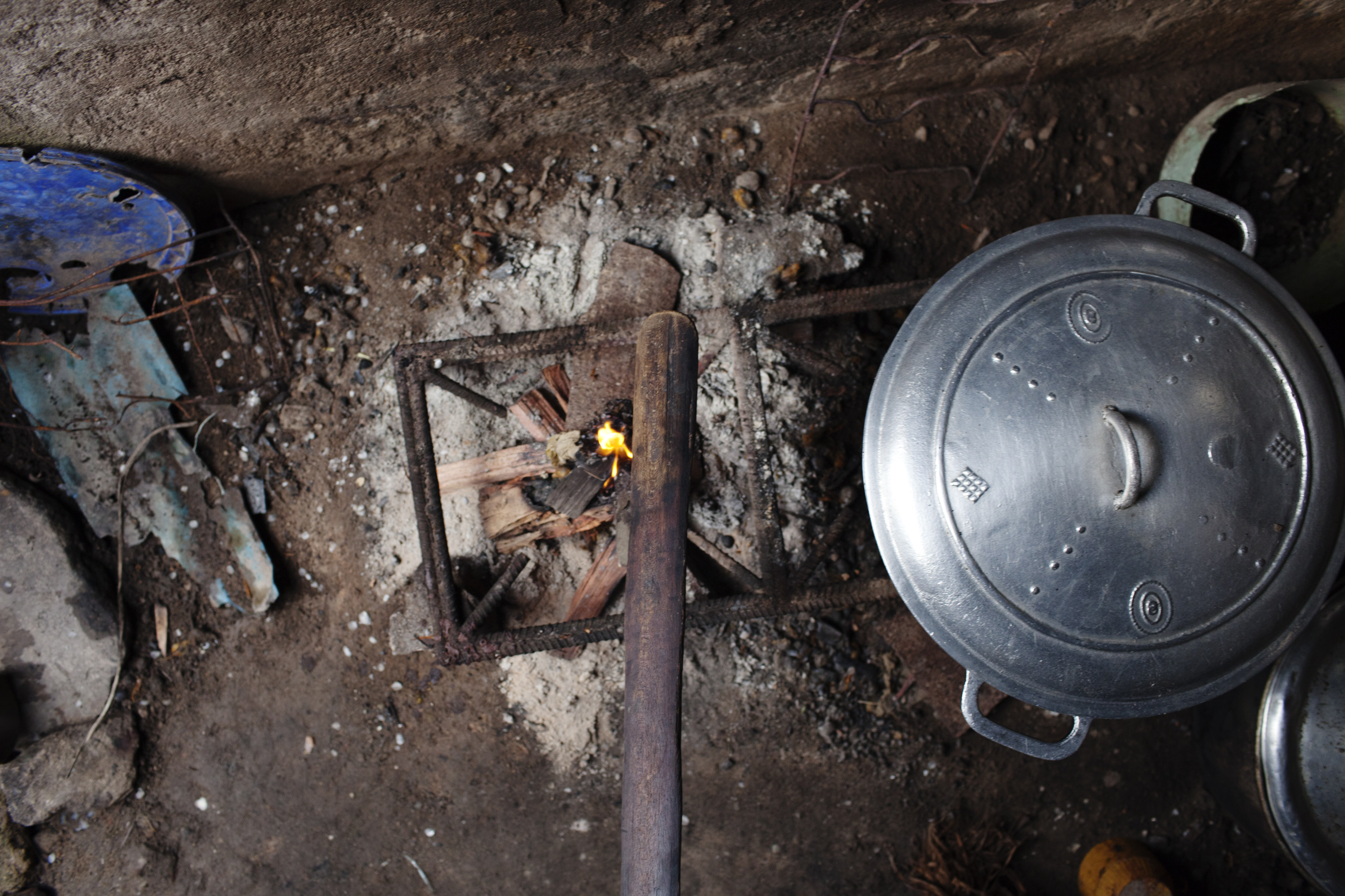 A stick used for breast ironing is seen on a fire at a survivor’s home in Cameroon