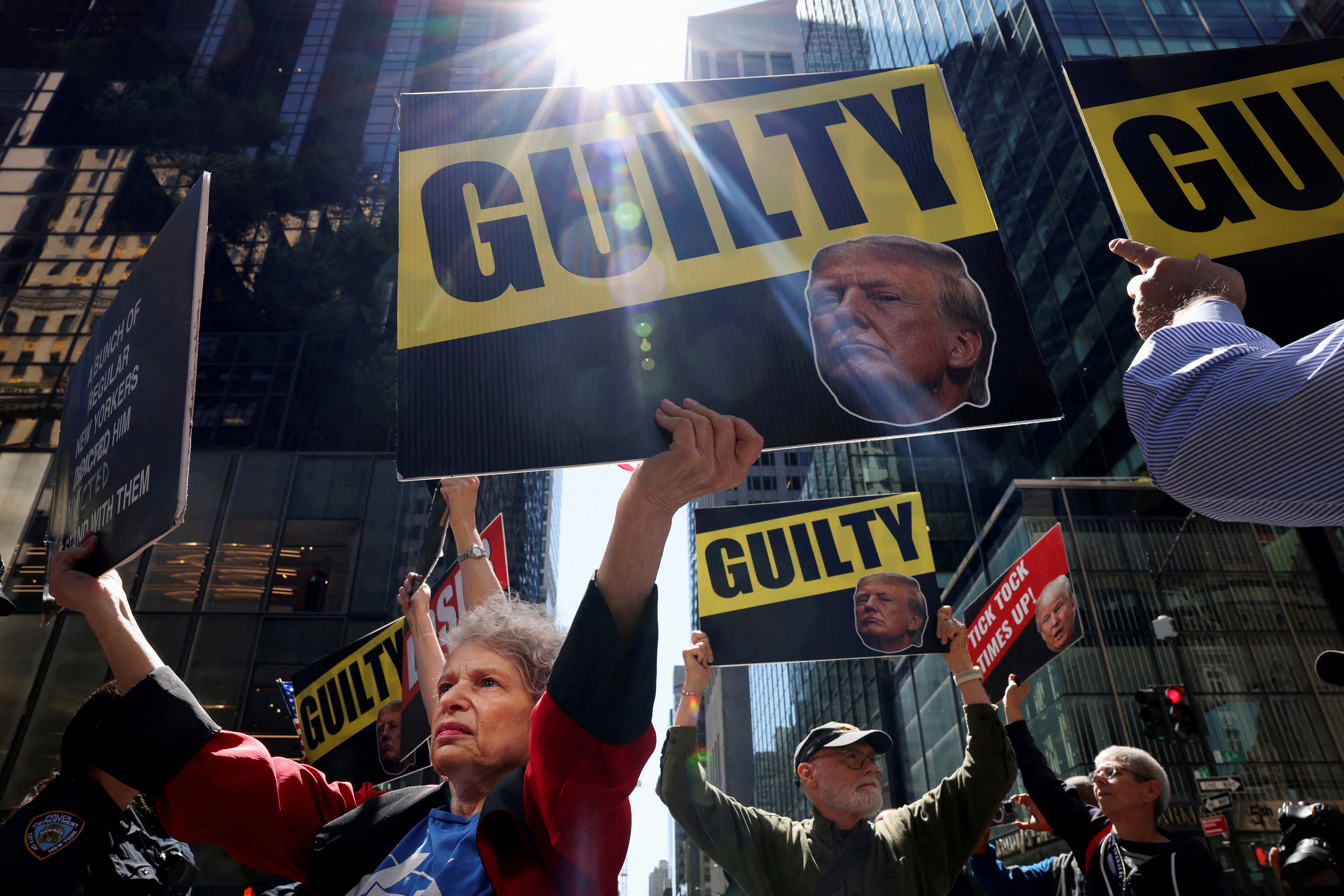 A protester in New York lifts up signs with Donald Trump's face with the word "Guilty"