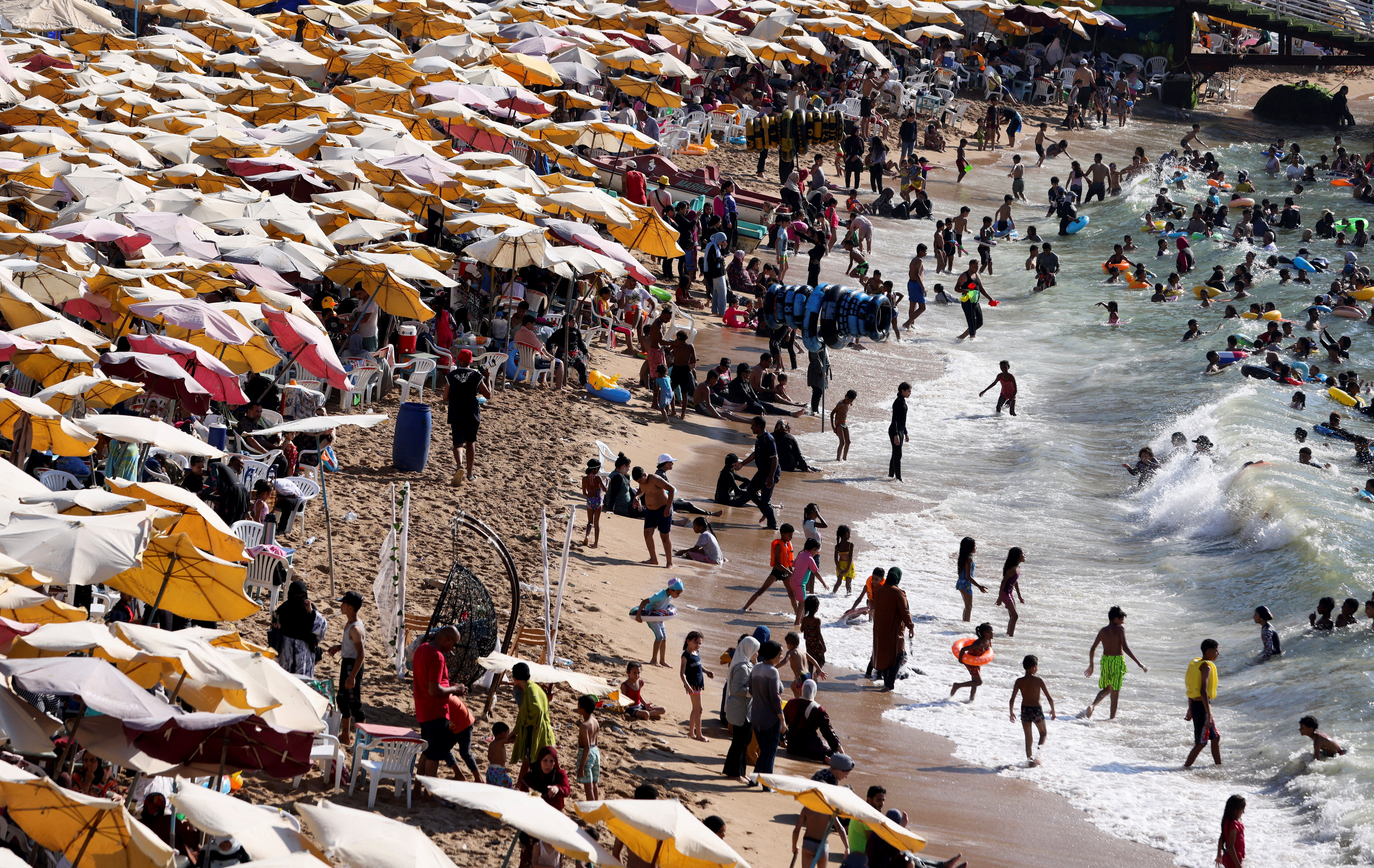 People crowd a public beach during a hot day amid a heatwave, in the Mediterranean city of Alexandria, Egypt