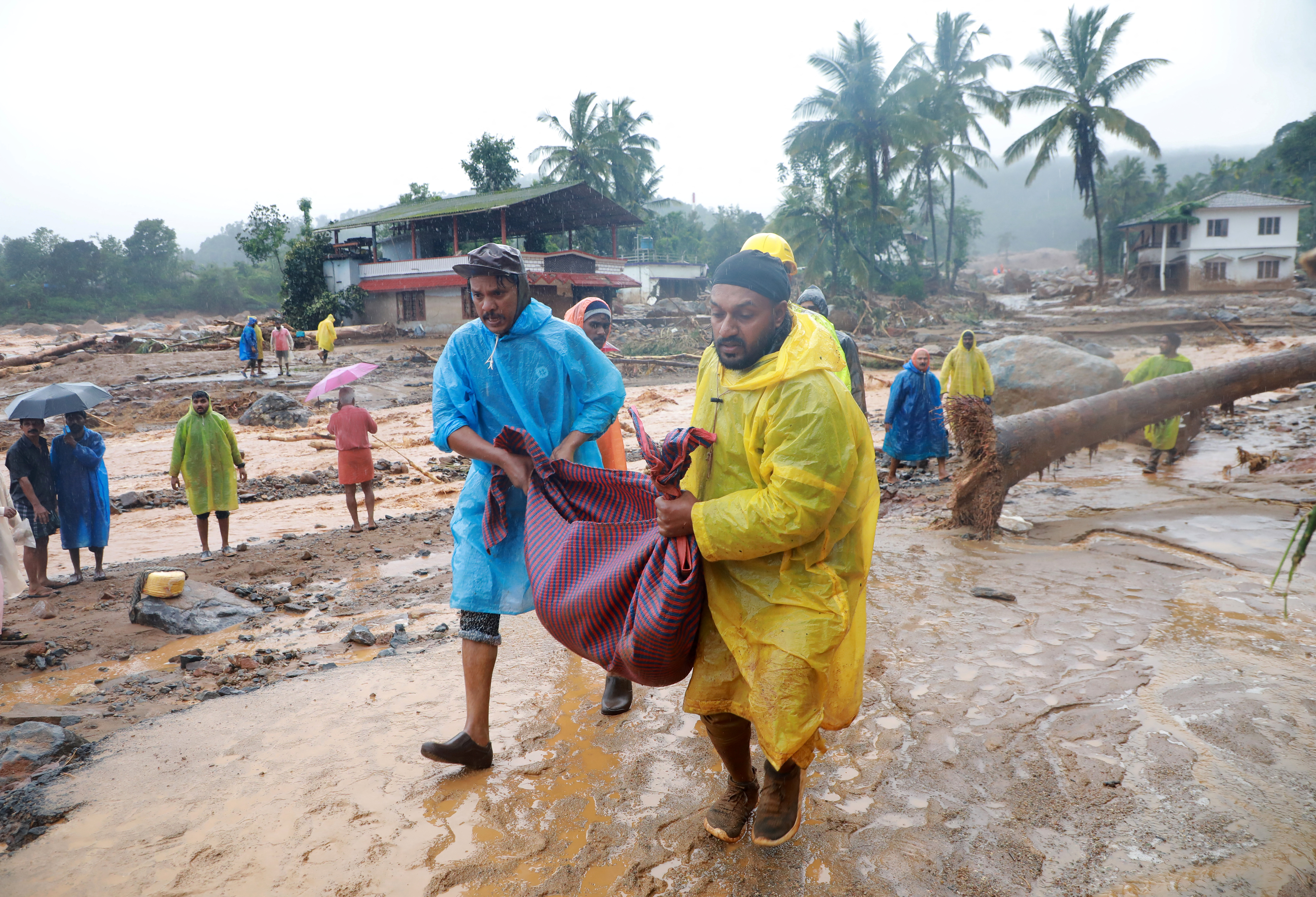 Rescuers carry the body of a victim after multiple landslides in Wayanad, Kerala, India