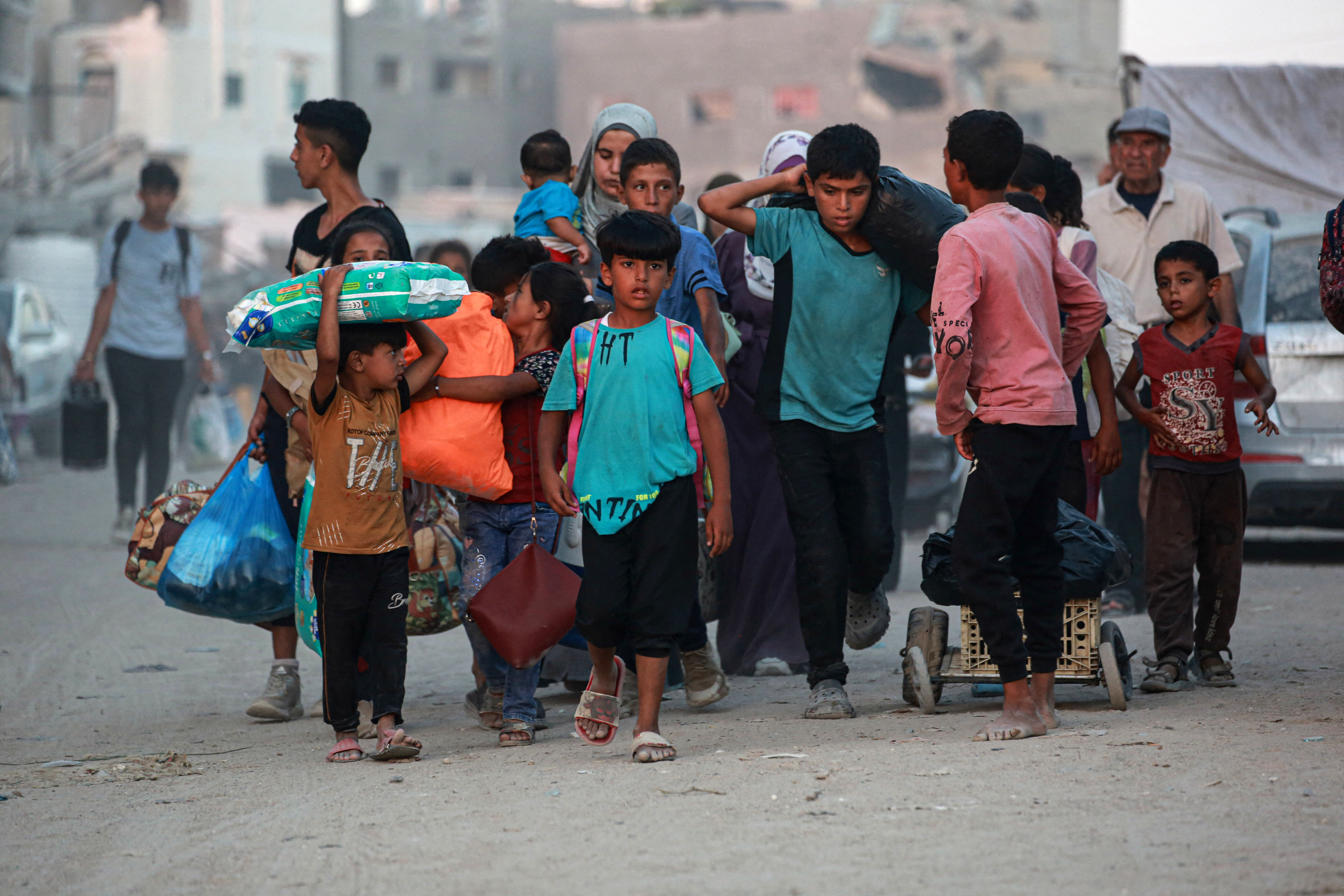 Children walk as displaced Palestinians leave an area in east Khan Yunis after the Israeli army issued a new evacuation order for parts of the city and Rafah, in the southern Gaza Strip on July 1, 2024, amid the ongoing conflict between Israel and the Palestinian Hamas militant group. (Photo by Bashar TALEB / AFP)