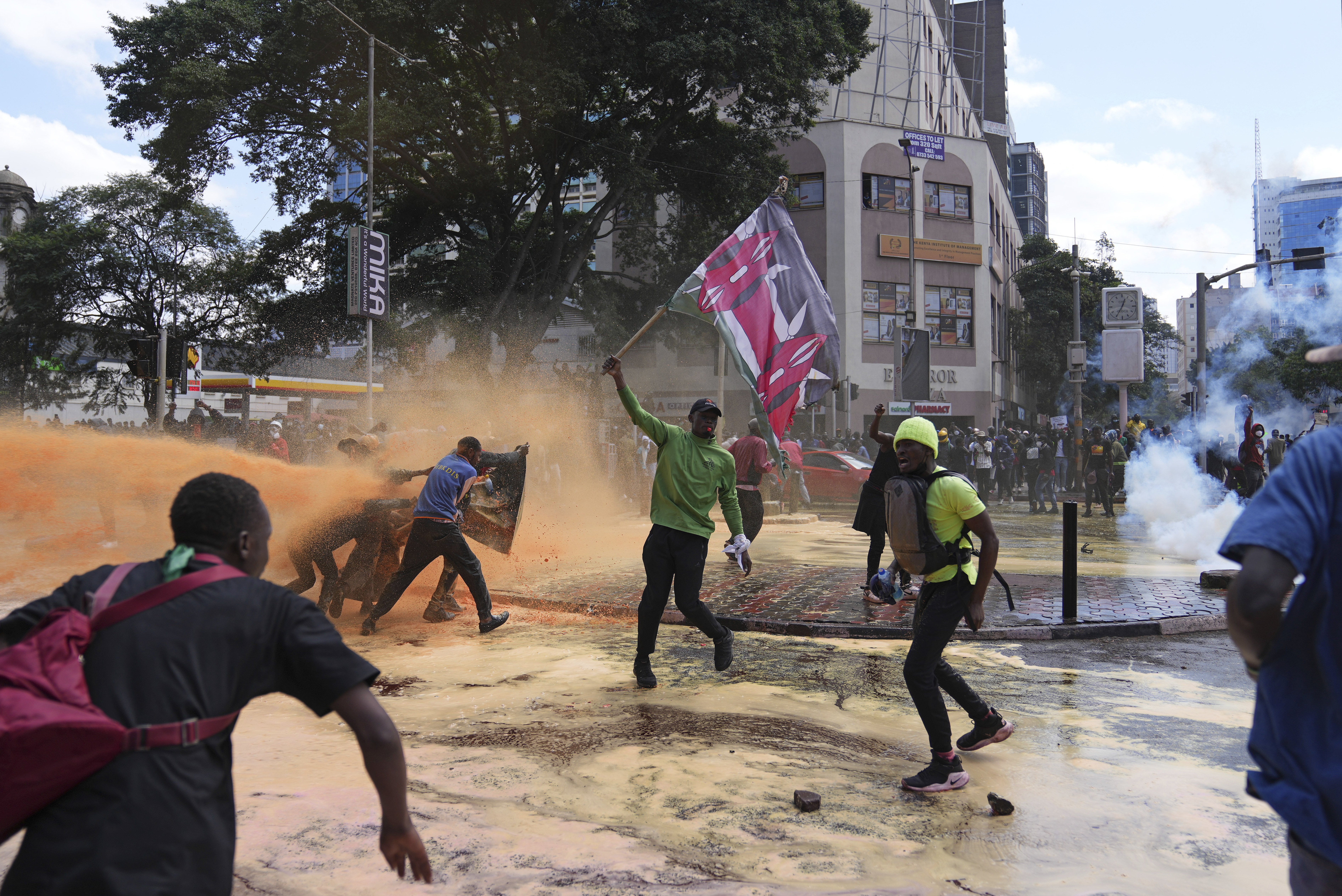Protesters scatter as Kenya police spray a water canon at them during a protest over proposed tax hikes in a finance bill in downtown Nairobi, Kenya, on June. 25, 2024