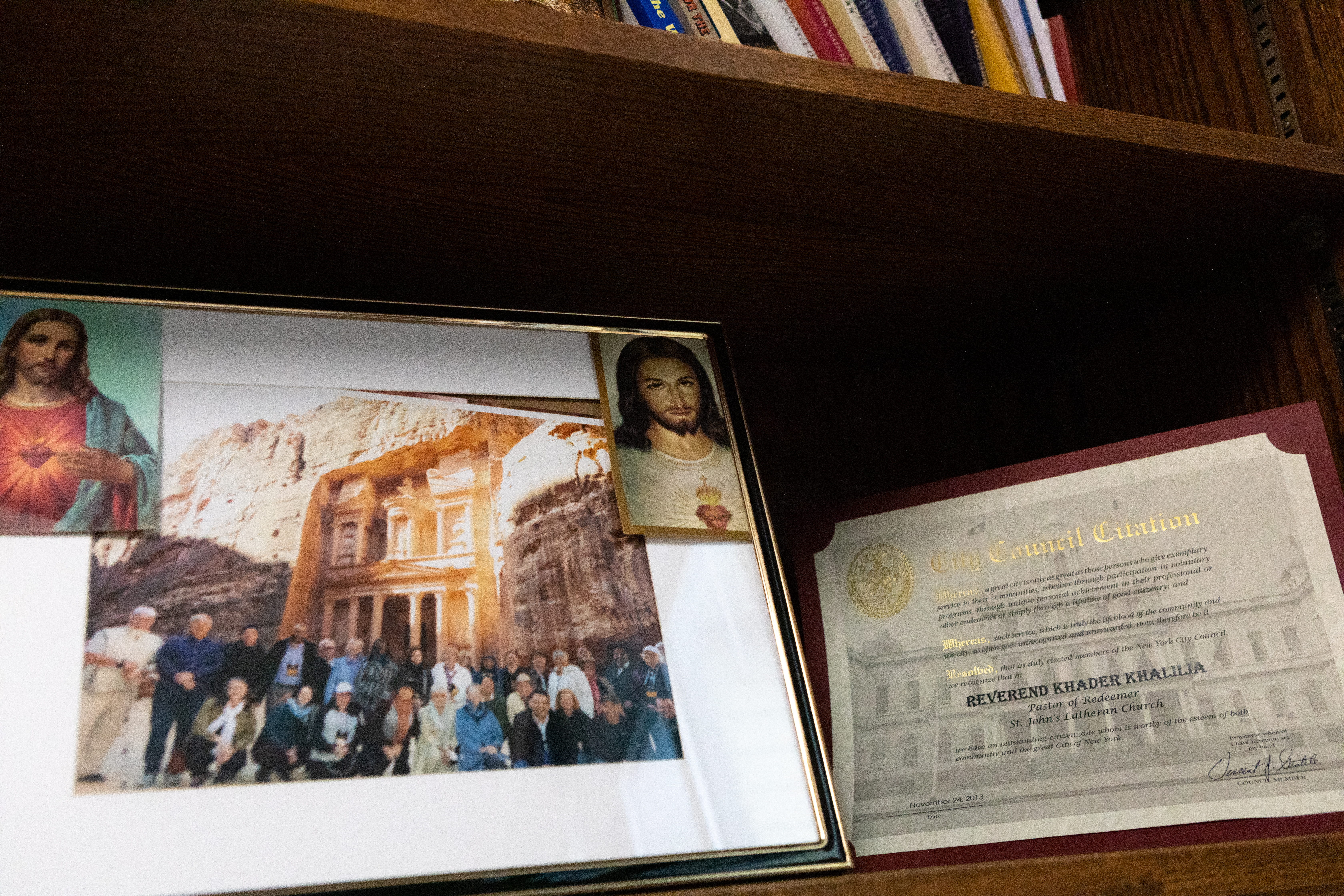 A framed photo of a church group in Jordan, with a Jesus picture pinned to one corner.