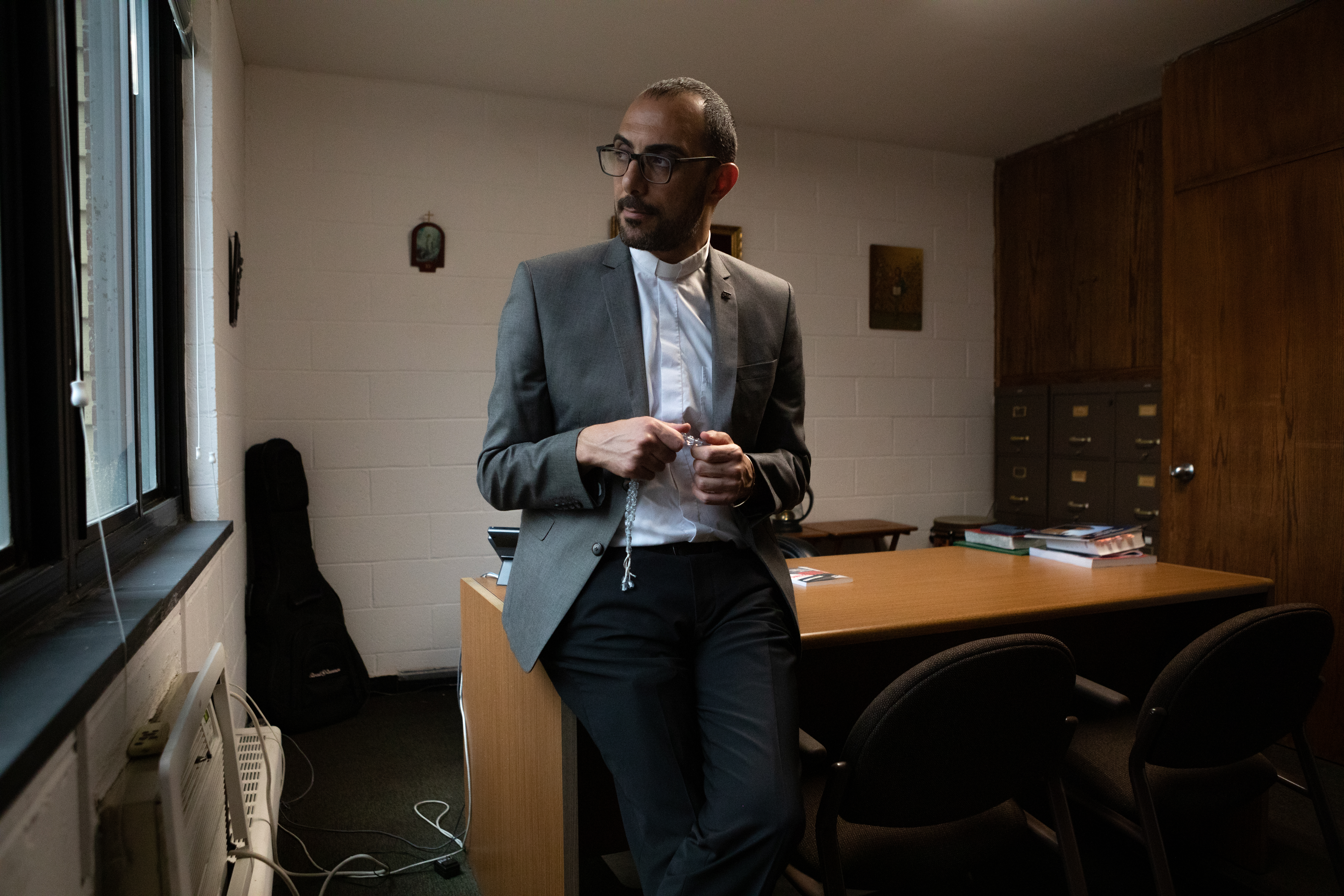 Pastor Khalilia poses for a portrait in his office at Redeemer-St. John's. He often reaches for the set of prayer beads in his hands, a gift from a shopkeeper in Bethlehem.