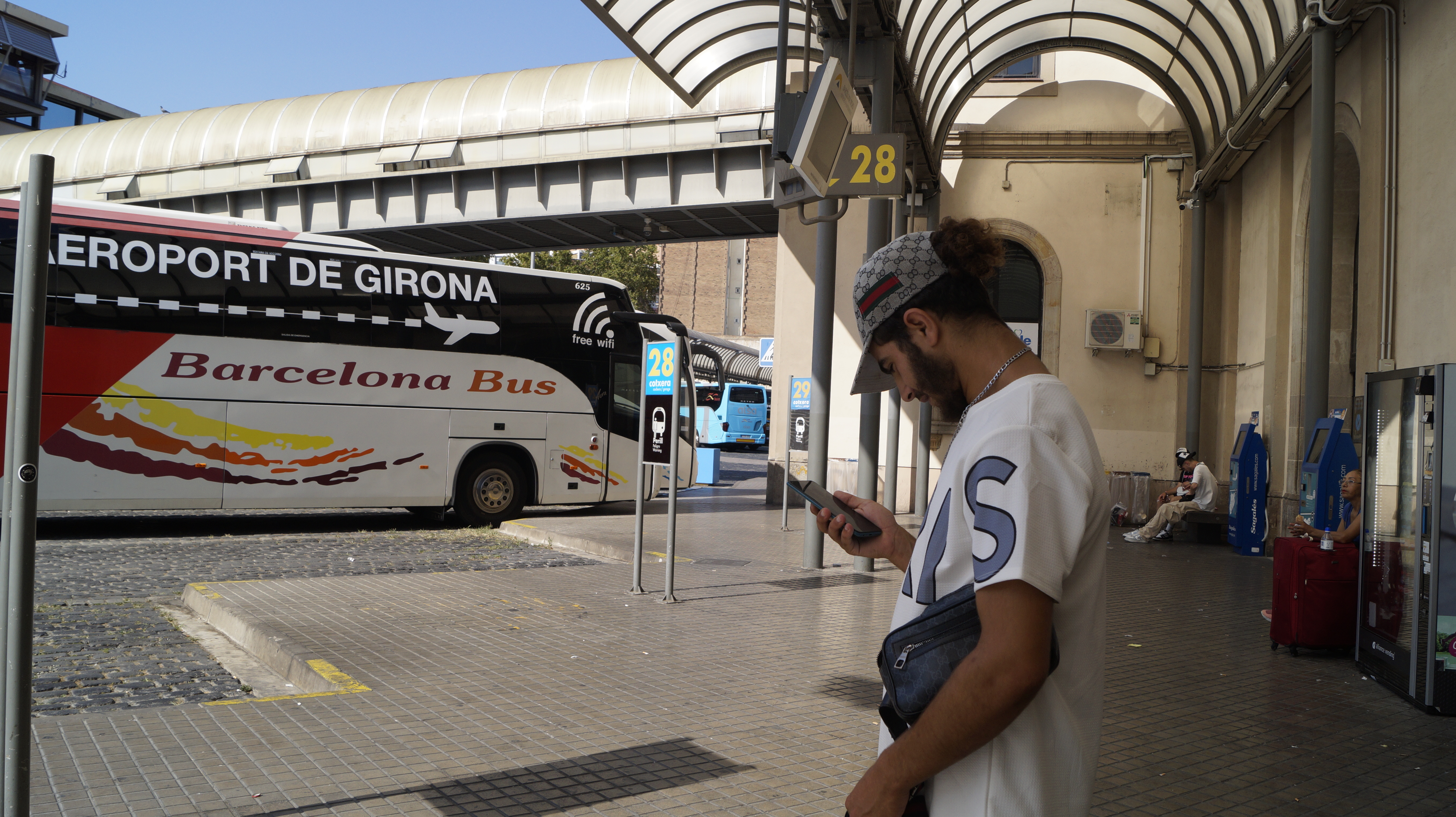 Ilyas looks at his phone in search of shelters at Barcelona’s central bus station. He has no place to sleep tonight