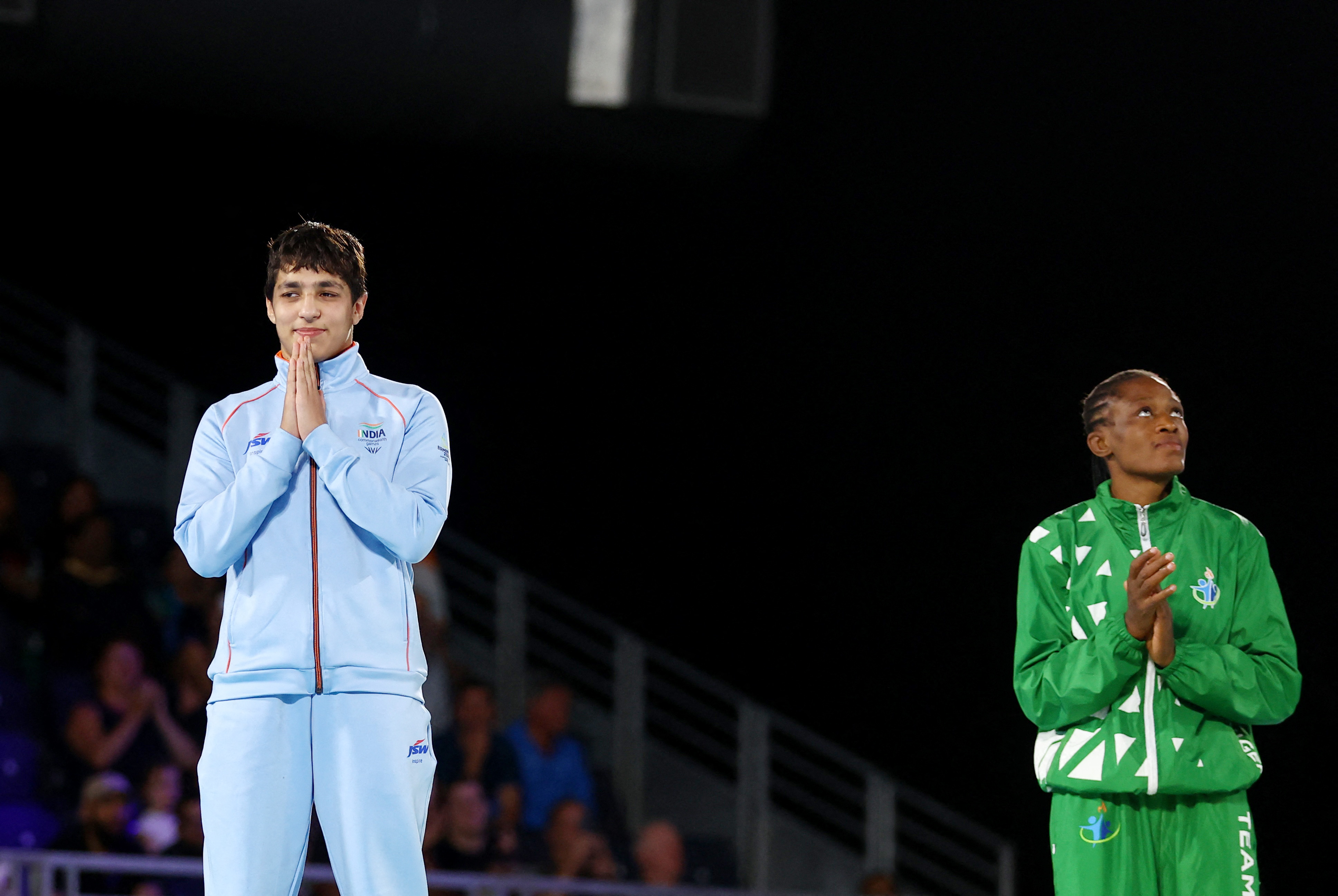 Commonwealth Games - Wrestling - Women's Freestyle 57kg - Medal Ceremony - Coventry Arena, Coventry, Britain - August 5, 2022 Gold medallist Nigeria's Odunayo Folasade Adekuoroye celebrates on the podium alongside silver medallist India's Anshu Malik during the medal ceremony REUTERS/Hannah Mckay