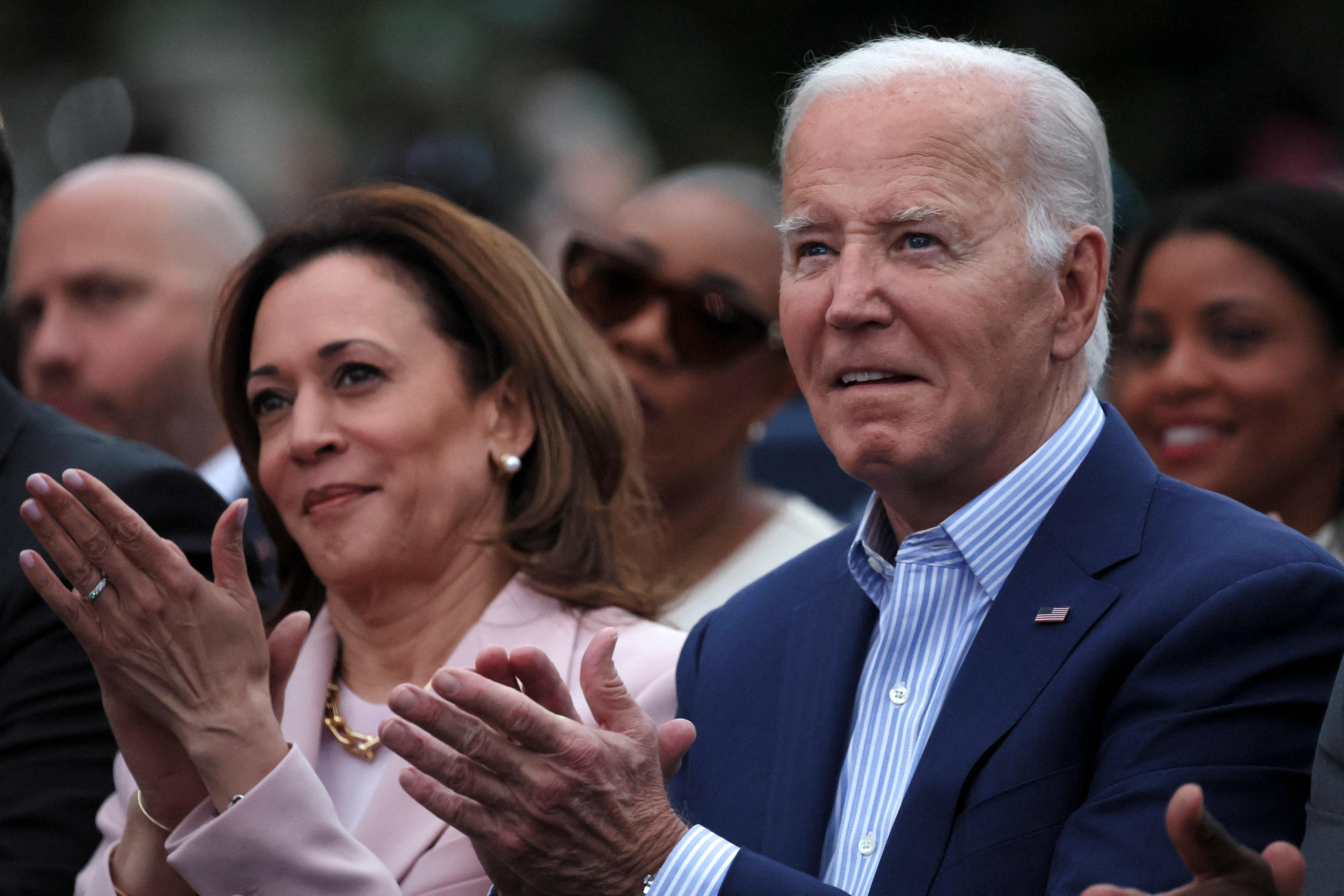 Joe Biden and Kamala Harris clap during an event at the White House