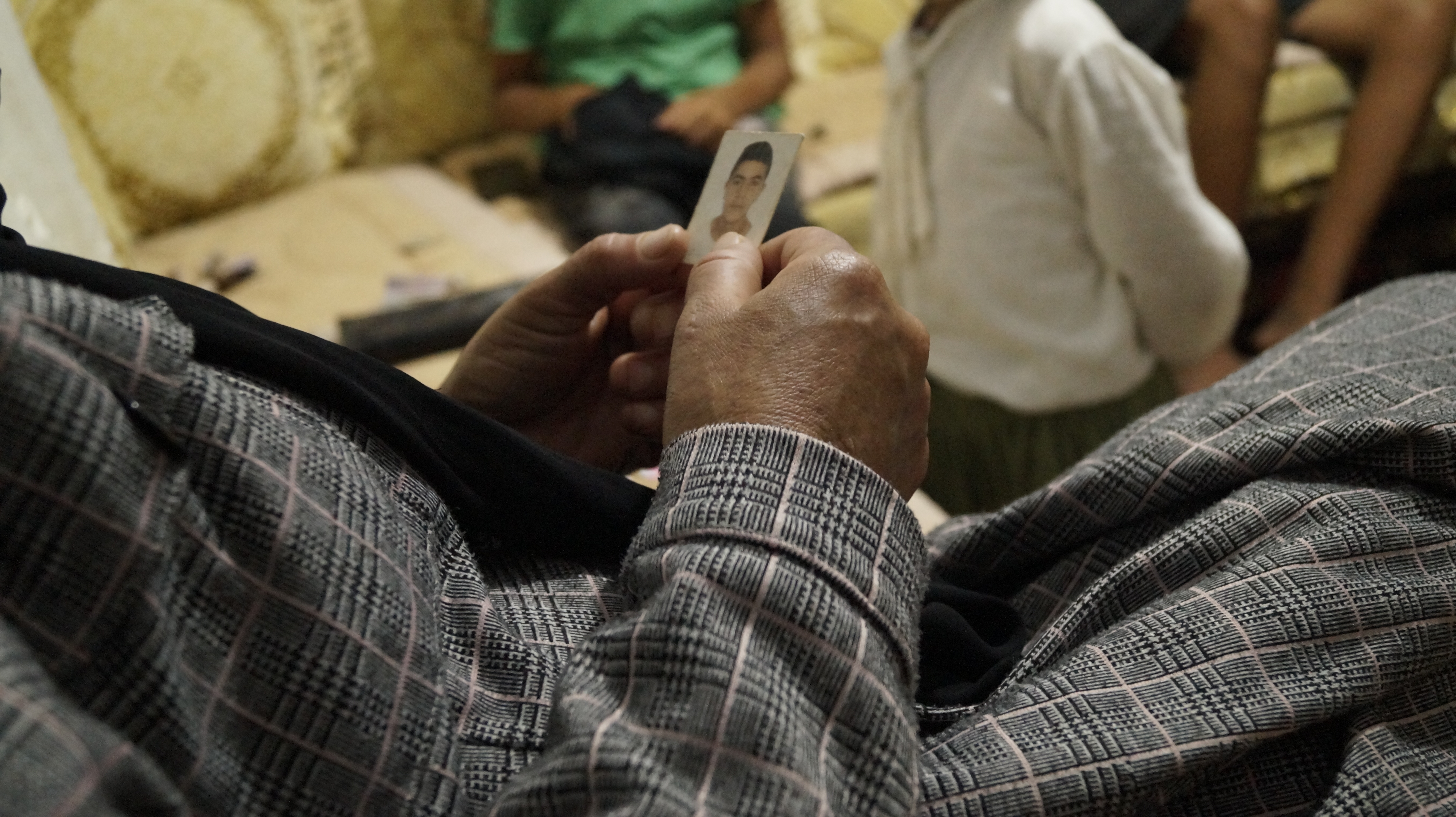 Aseya looks at her son’s picture and kisses it as she prays he will soon find a place to stay off the streets in Barcelona