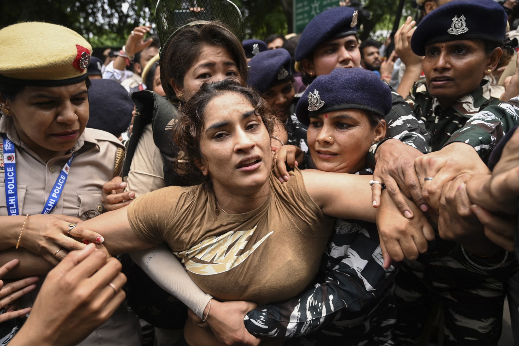 Indian wrestler Vinesh Phogat (C) is detained by the police while attempting to march to India's new parliament, just as it was being inaugurated by Prime Minister Narendra Modi, during a protest against Brij Bhushan Singh, the wrestling federation chief, over allegations of sexual harassment and intimidation, in New Delhi on May 28, 2023. (Photo by Arun THAKUR / AFP)