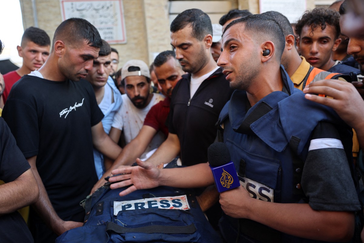 Mourners and colleagues surround the body of Al-Jazeera Arabic journalist Ismail al-Ghoul, killed along with his cameraman Rami al-Refee in an Israeli strike