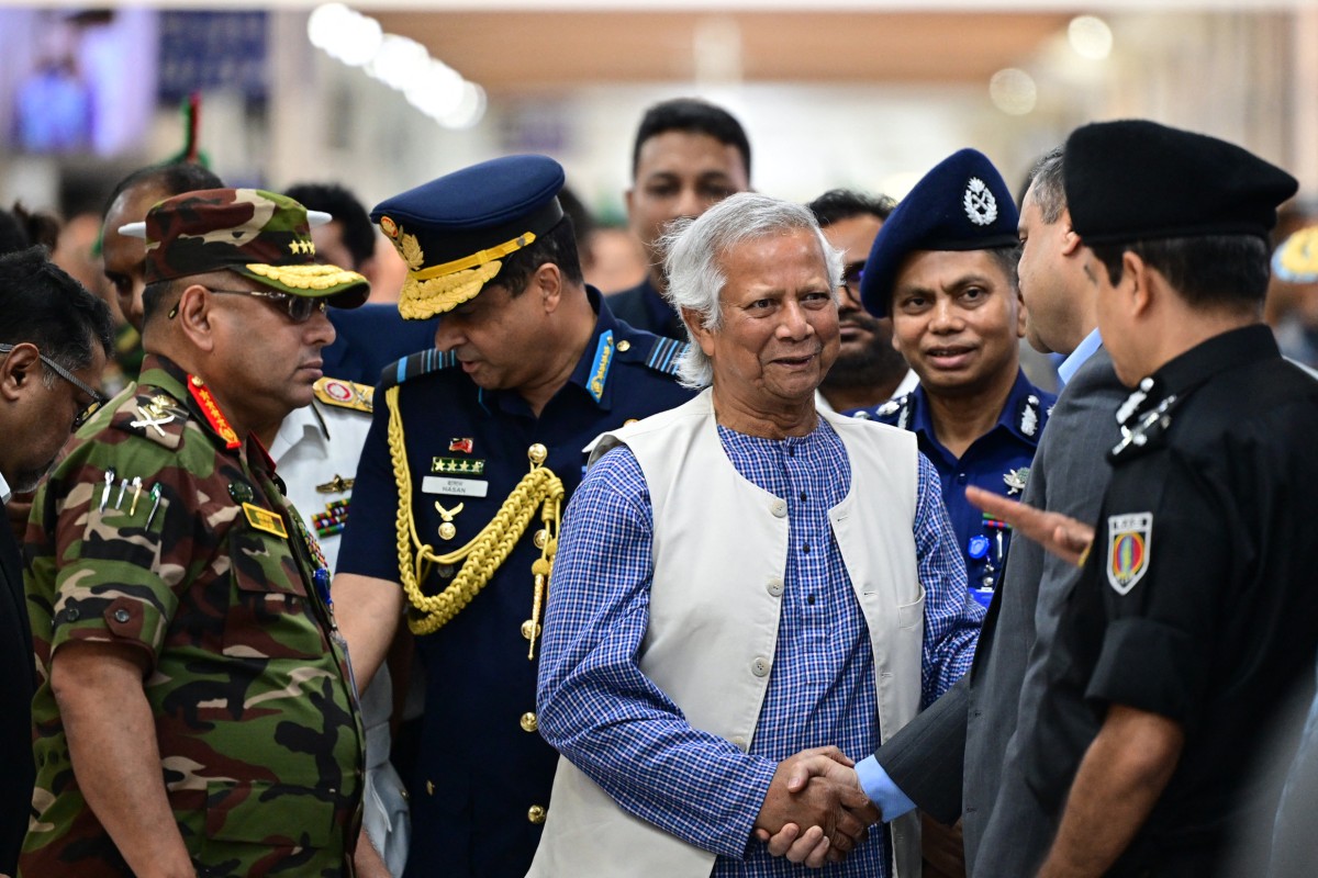 Nobel laureate Muhammad Yunus (C) meets government officials as Bangladesh's Army chief General Waker-Uz-Zaman (L) watches, upon Yunus's arrival at the Hazrat Shahjalal International Airport in Dhaka on August 8, 2024. - Nobel Peace Prize winner Muhammad Yunus hailed Bangladesh's "second independence" as he returned on August 8, to lead his country back to democracy after a student-led uprising ended the 15-year rule of Sheikh Hasina. (Photo by MUNIR UZ ZAMAN / AFP)
