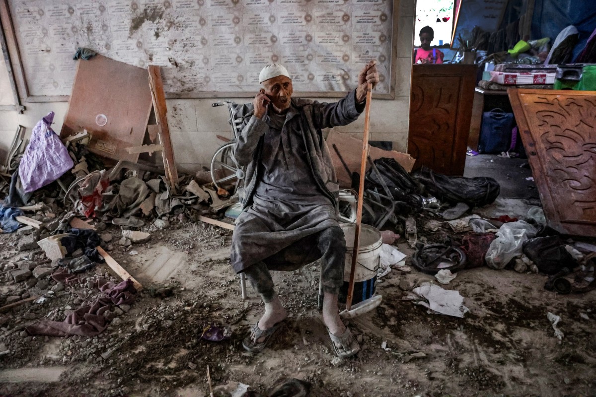 An elderly man sits amid the rubble inside a school used as a temporary shelter for displaced Palestinians in Gaza City, after it was hit by an Israeli strike on August 10, 2024, that killed more than 90 people, as the conflict between Israel and the Hamas movement continues. (Photo by Omar AL-QATTAA / AFP)