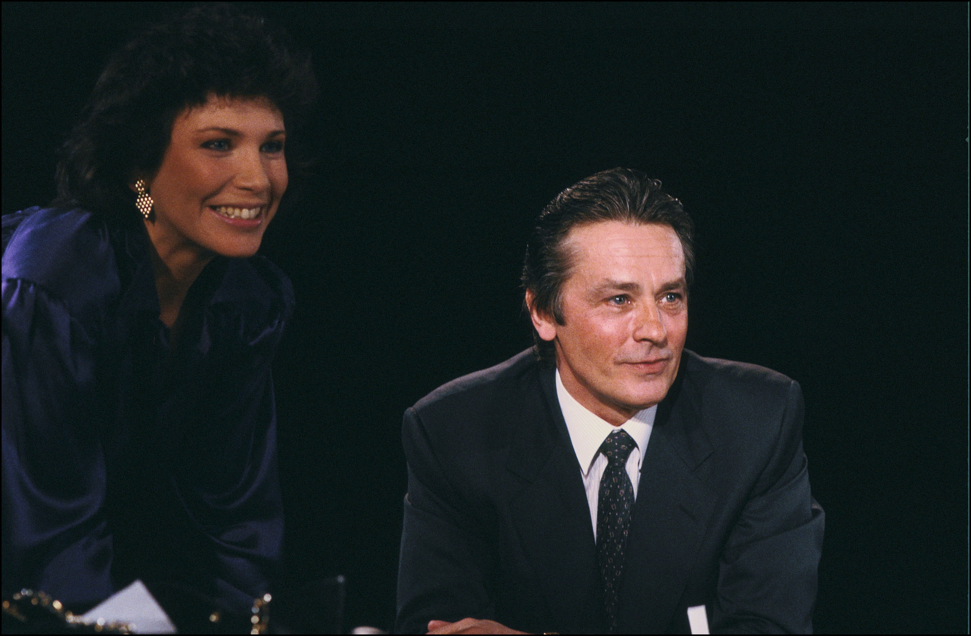 Anne Sinclair and Alain Delon in the TV series 7 sur7, 1988 [Arnal Gamma-Rapho via Getty Images]