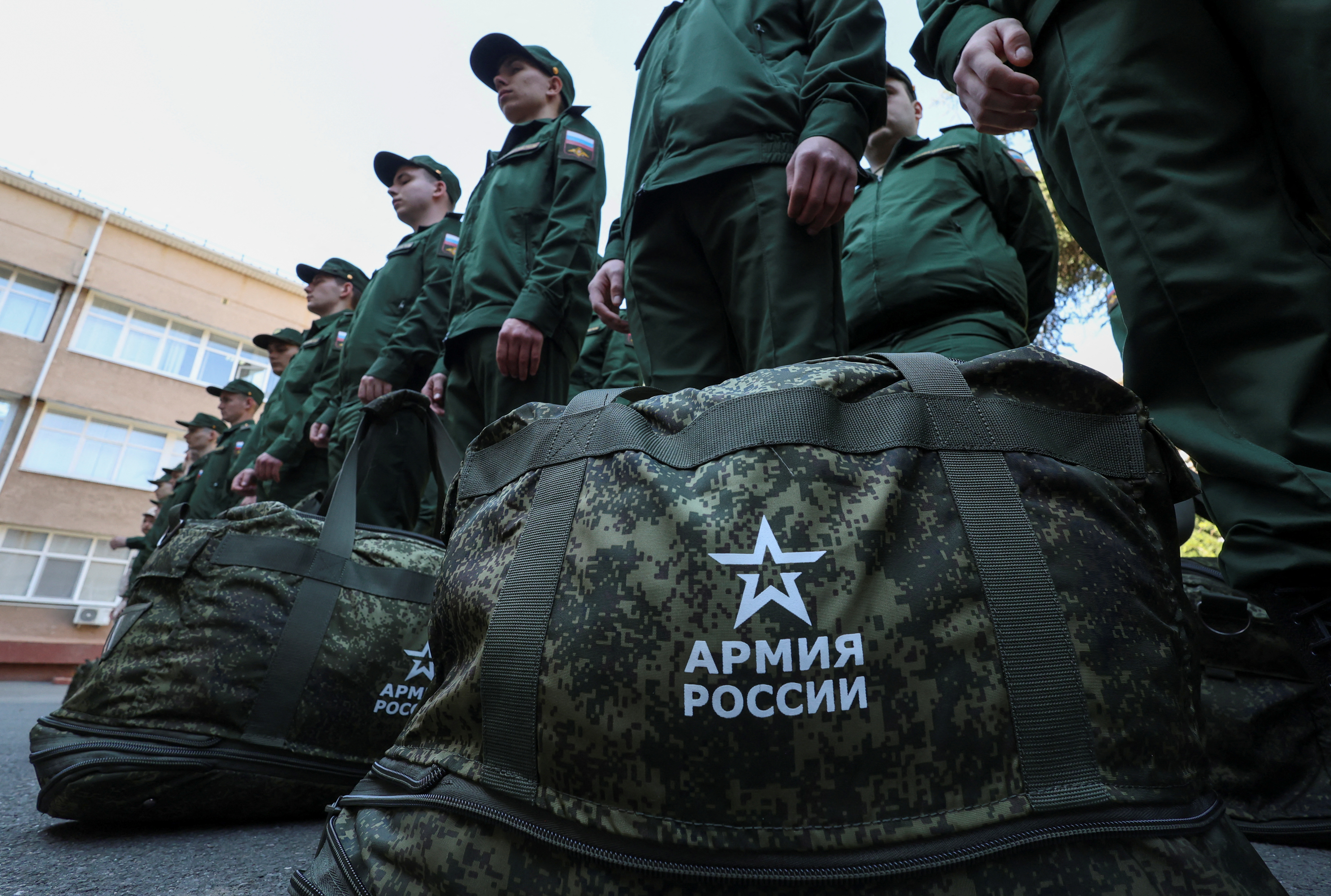 Russian conscripts called up for military service line up before their departure for garrisons as they gather at a recruitment centre in Simferopol, Crimea, April 25, 2023. Signs on bags read: "Army of Russia". REUTERS/Alexey Pavlishak