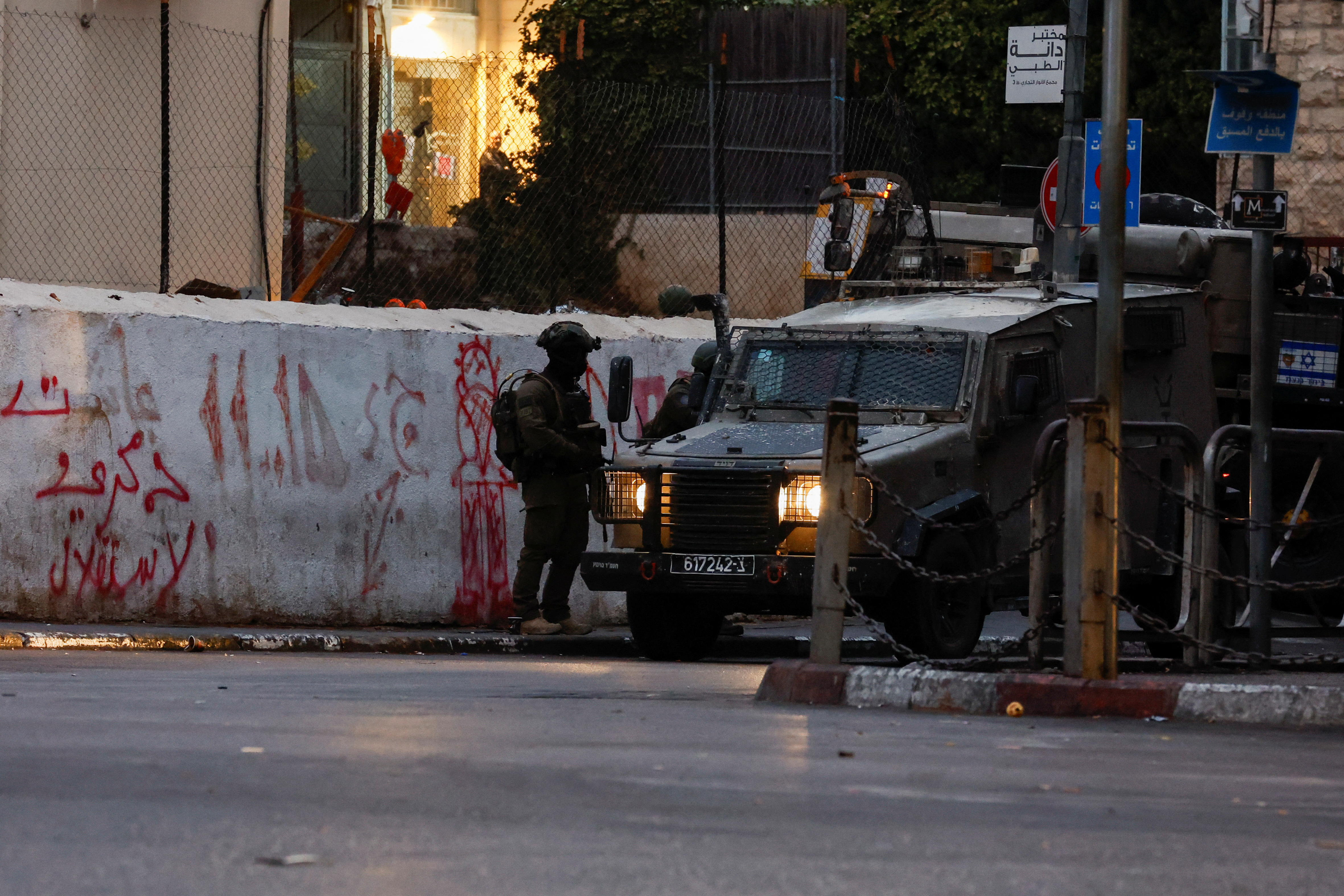 a soldier stands near a military vehicle