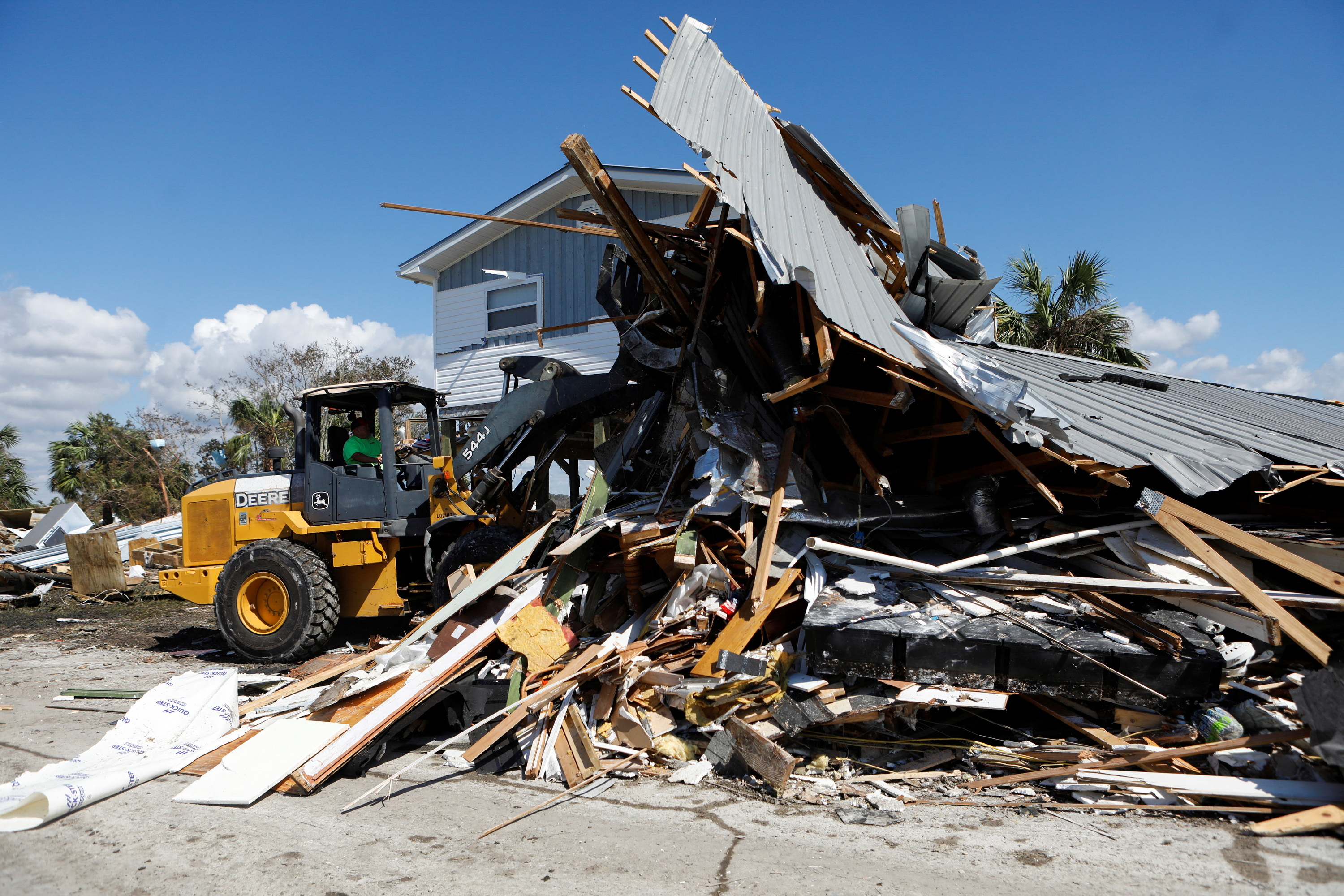 A man operating a front loader clears a home from the road that was destroyed in Keaton Beach after Hurricane Helene passed through the Florida panhandle