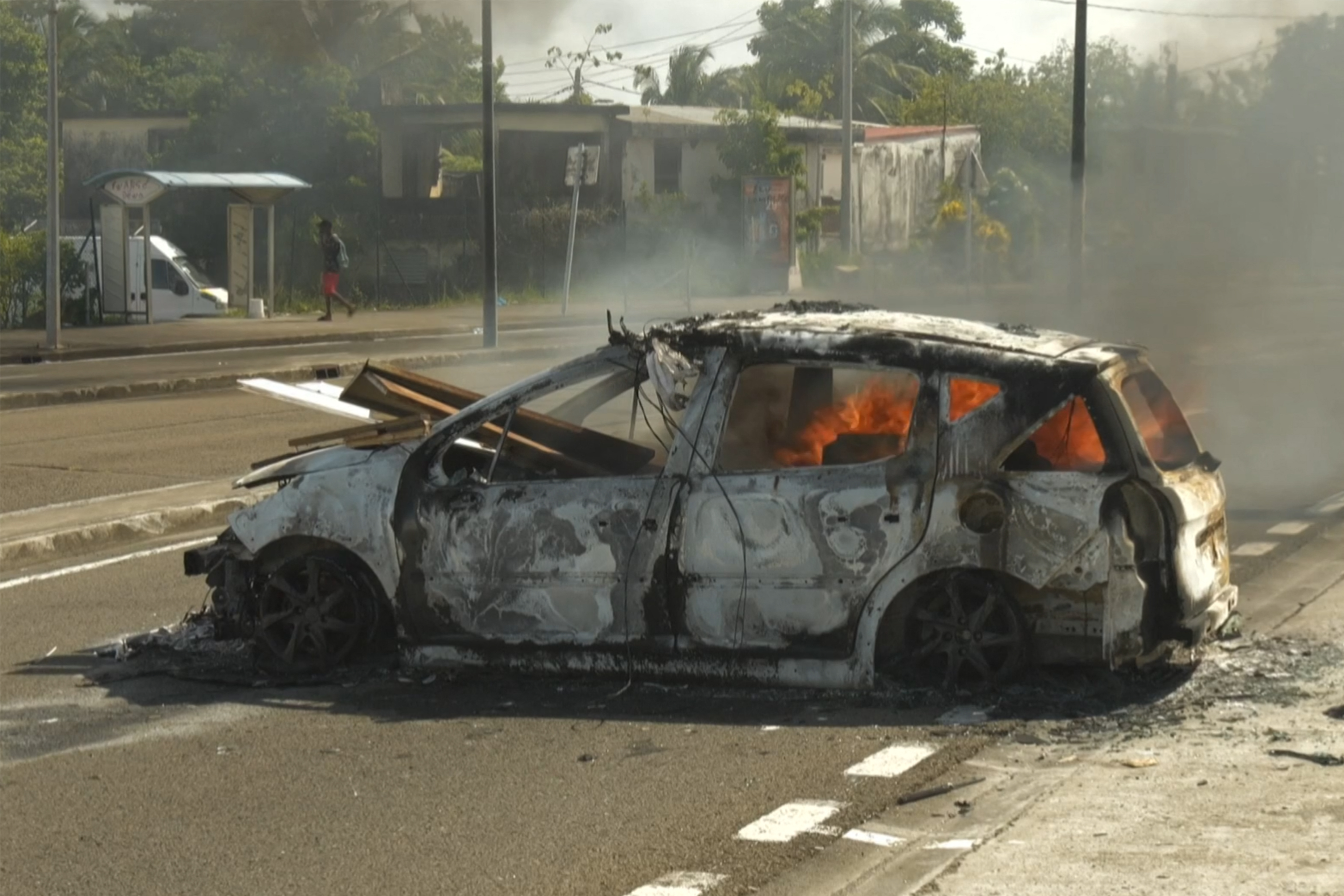 TOPSHOT - An image taken from an AFP video released on September 17, 2024 shows a car burning in a street of Fort-de-France in the French Caribbean island of Martinique following a night of riots amid protests over the high cost of living. Officials in the French Caribbean island of Martinique say on September 17, 2024 at least six police officers have been injured by gunfire during violent protests over the high cost of living. Martinique has seen similar protests in recent years, many of them fueled by anger over what demonstrators say is economic, social and racial inequality. (Photo by Thomas THURAR / AFP)