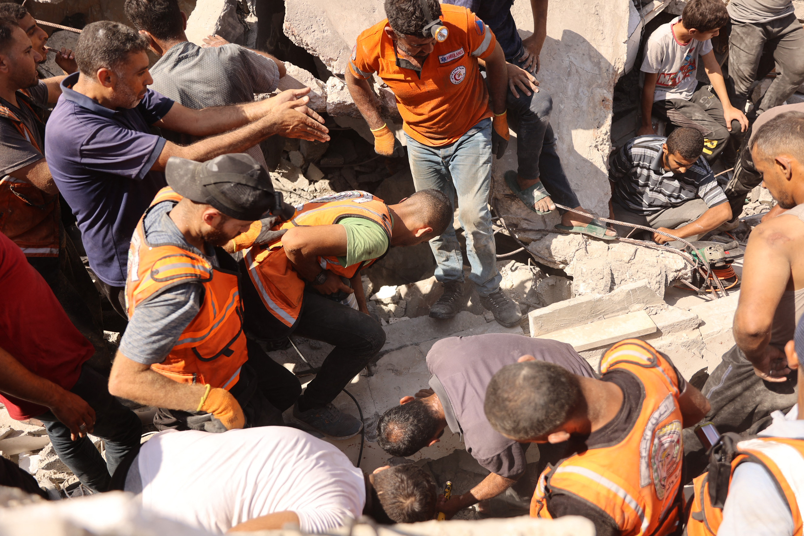 Palestinians search for survivors amidst the rubble of a building in Gaza