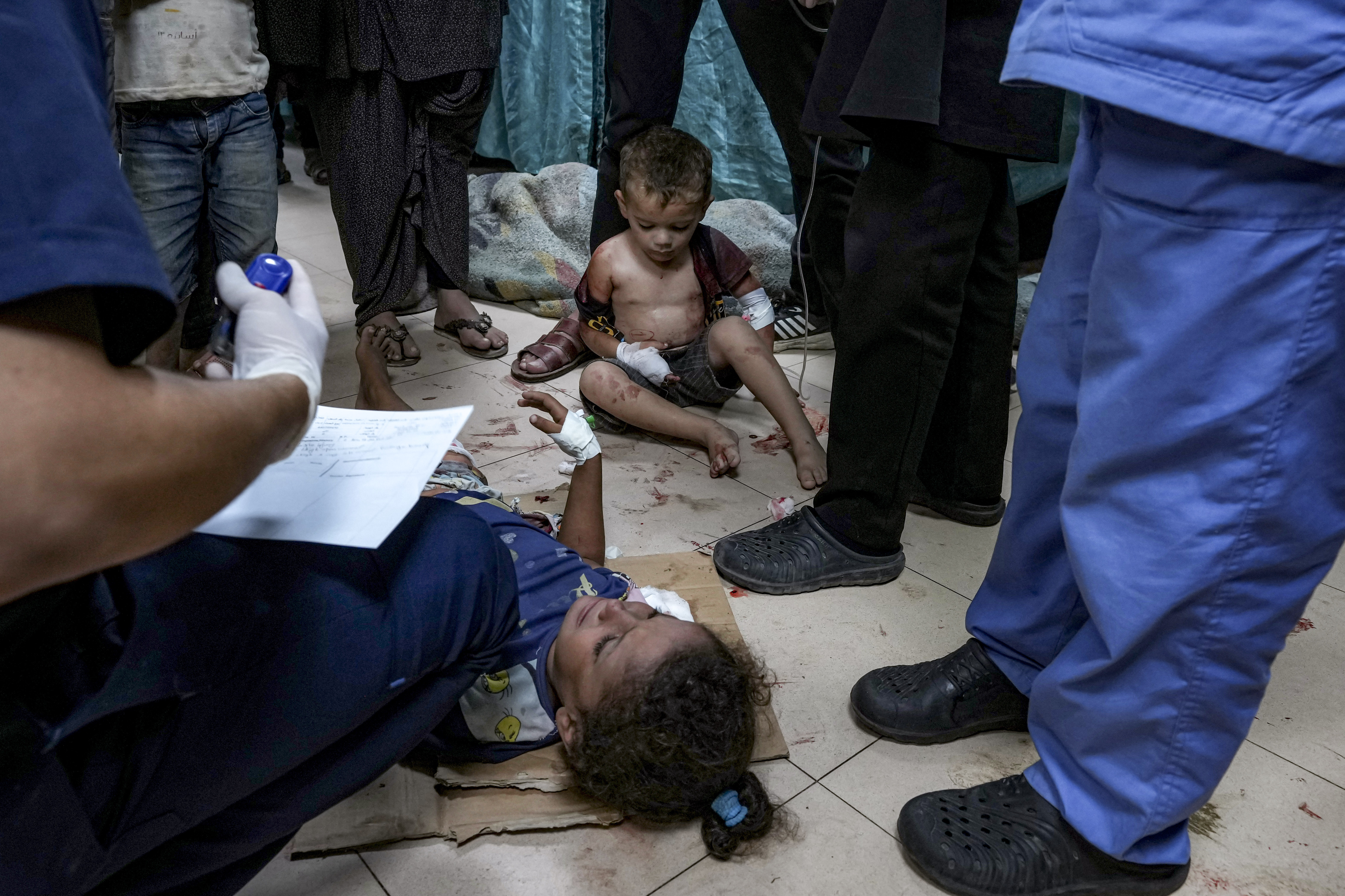 Palestinian children wounded in an Israeli bombardment are treated at an overwhelmed hospital in Deir el-Balah [Abdel Kareem Hana/AP]