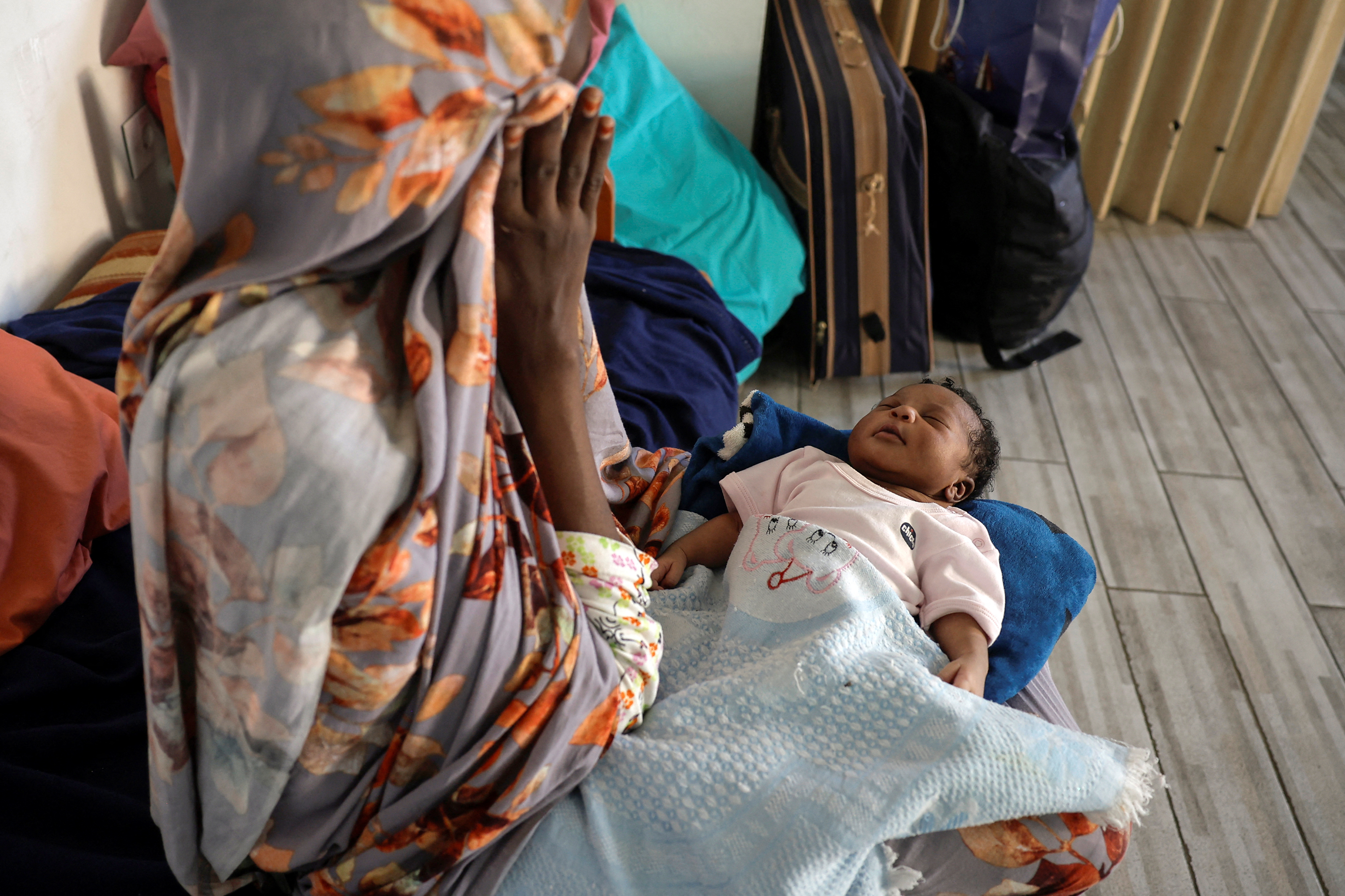 Zeinab from Sudan holds her newborn baby girl in the temporary shelter for migrants at St. Joseph Church in Beirut, Lebanon October 1, 2024. REUTERS/Louisa Gouliamaki