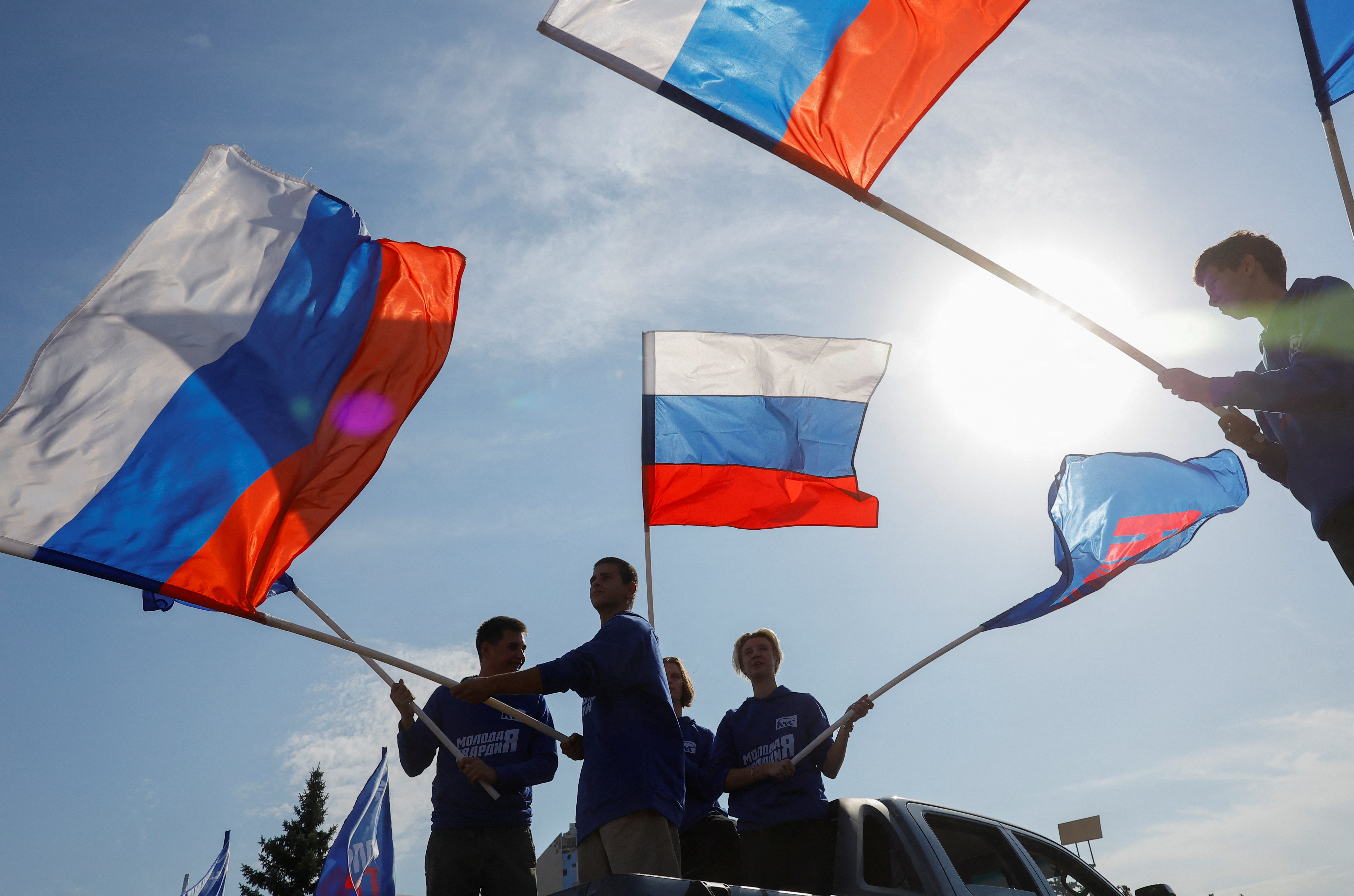 Activists wave flags during an event marking Russian President Vladimir Putin's 72nd birthday in the course of Russia-Ukraine conflict in Donetsk, Russian-controlled Ukraine, October 7, 2024. REUTERS/Alexander Ermochenko