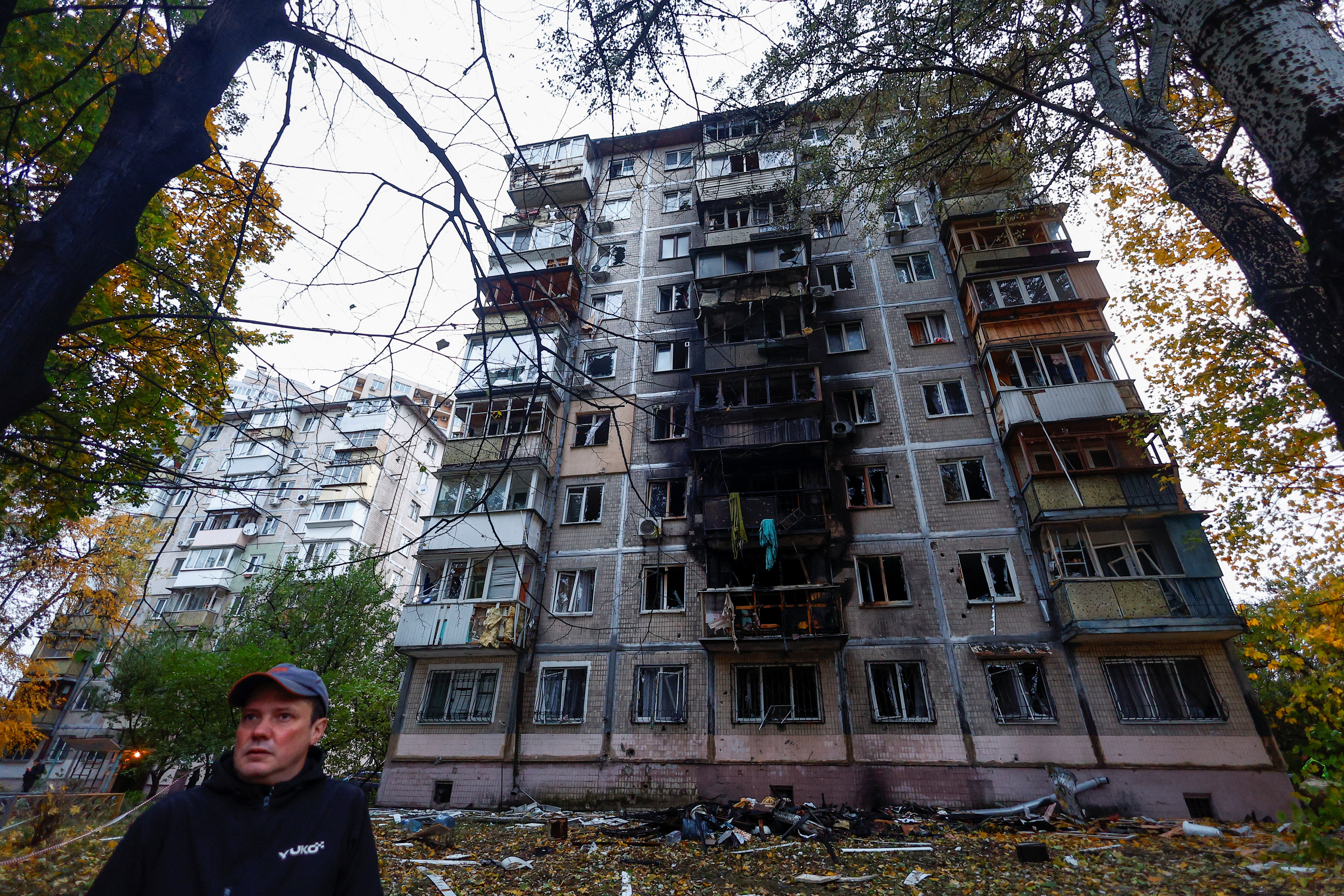 A resident stands in front of an apartment building damaged by a Russian drone strike, amid Russia’s attack on Ukraine, in Kyiv