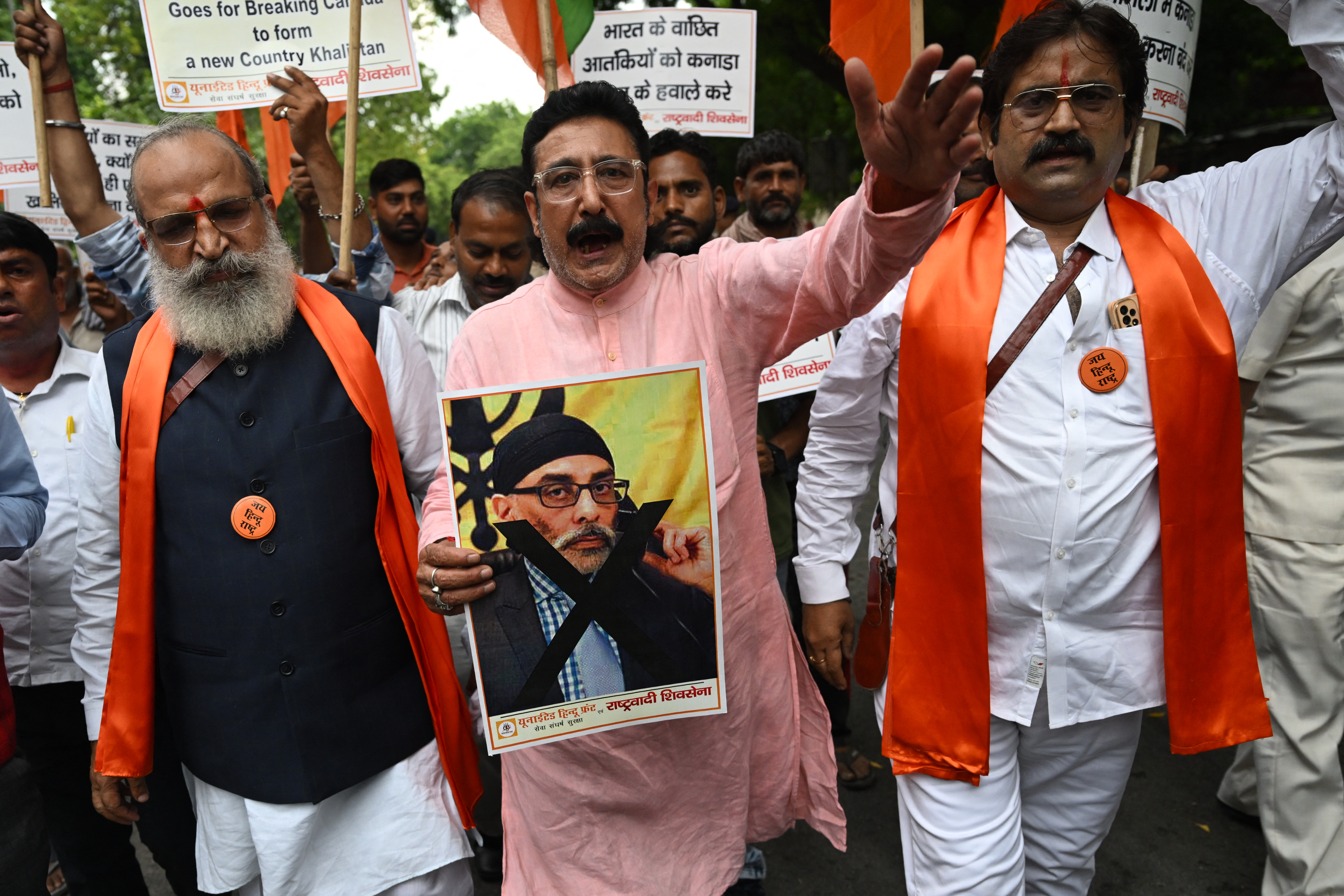 A member of United Hindu Front organisation shouts slogans while holding a banner depicting Gurpatwant Singh Pannun