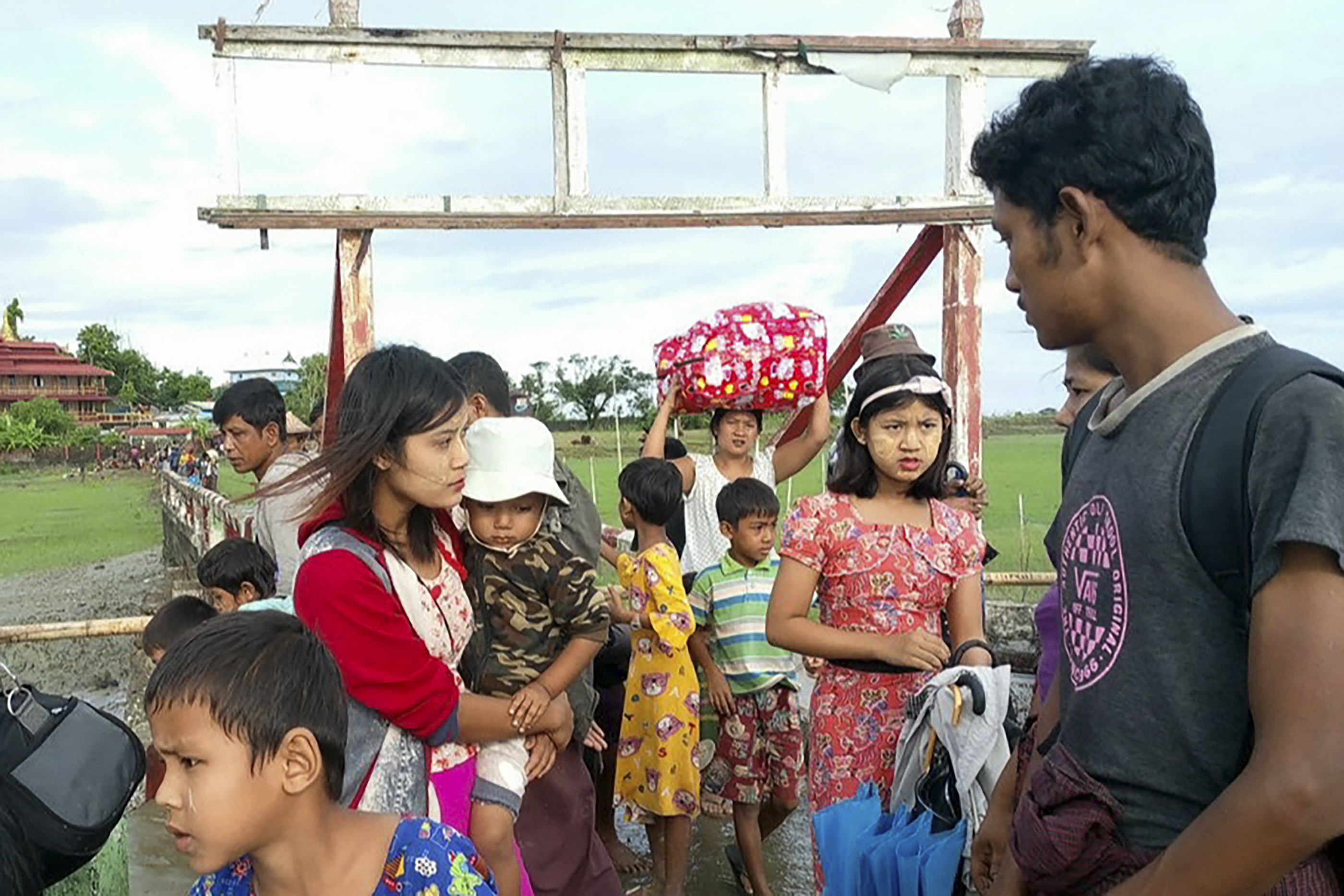 Women and children after fleeing from a village in Rakhine. They are carrying some of their belongings.